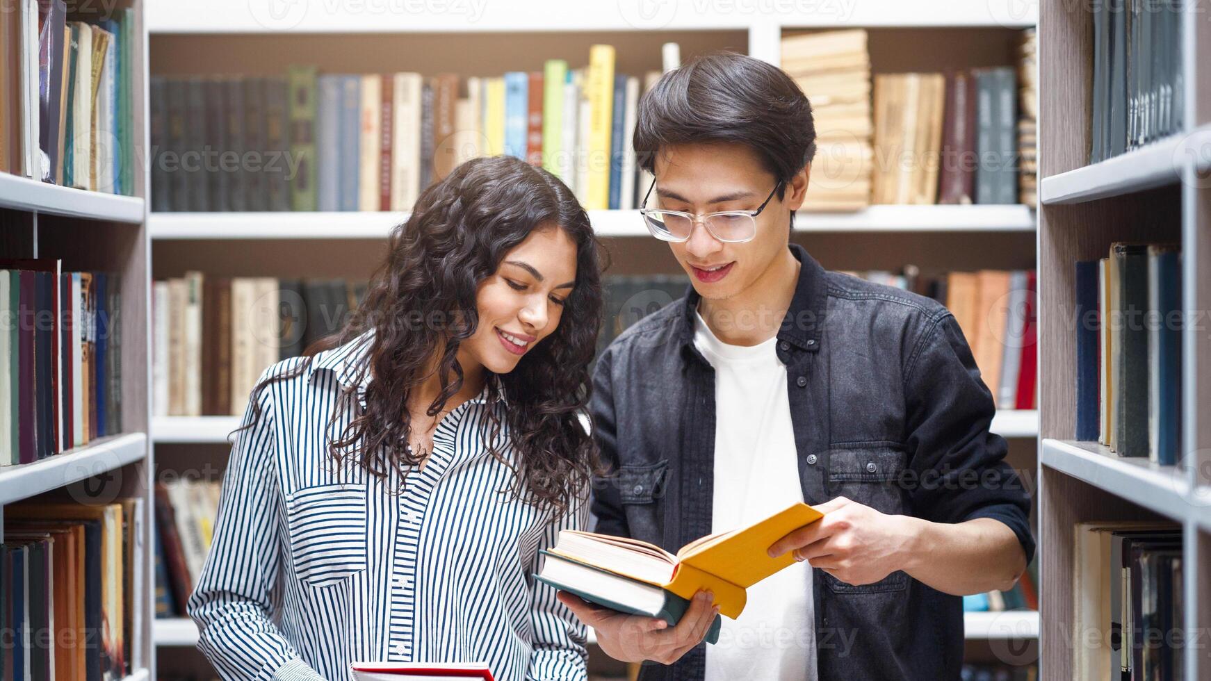Student Exchange Program. Two multiracial students standing in university library, reading books, copyspace photo