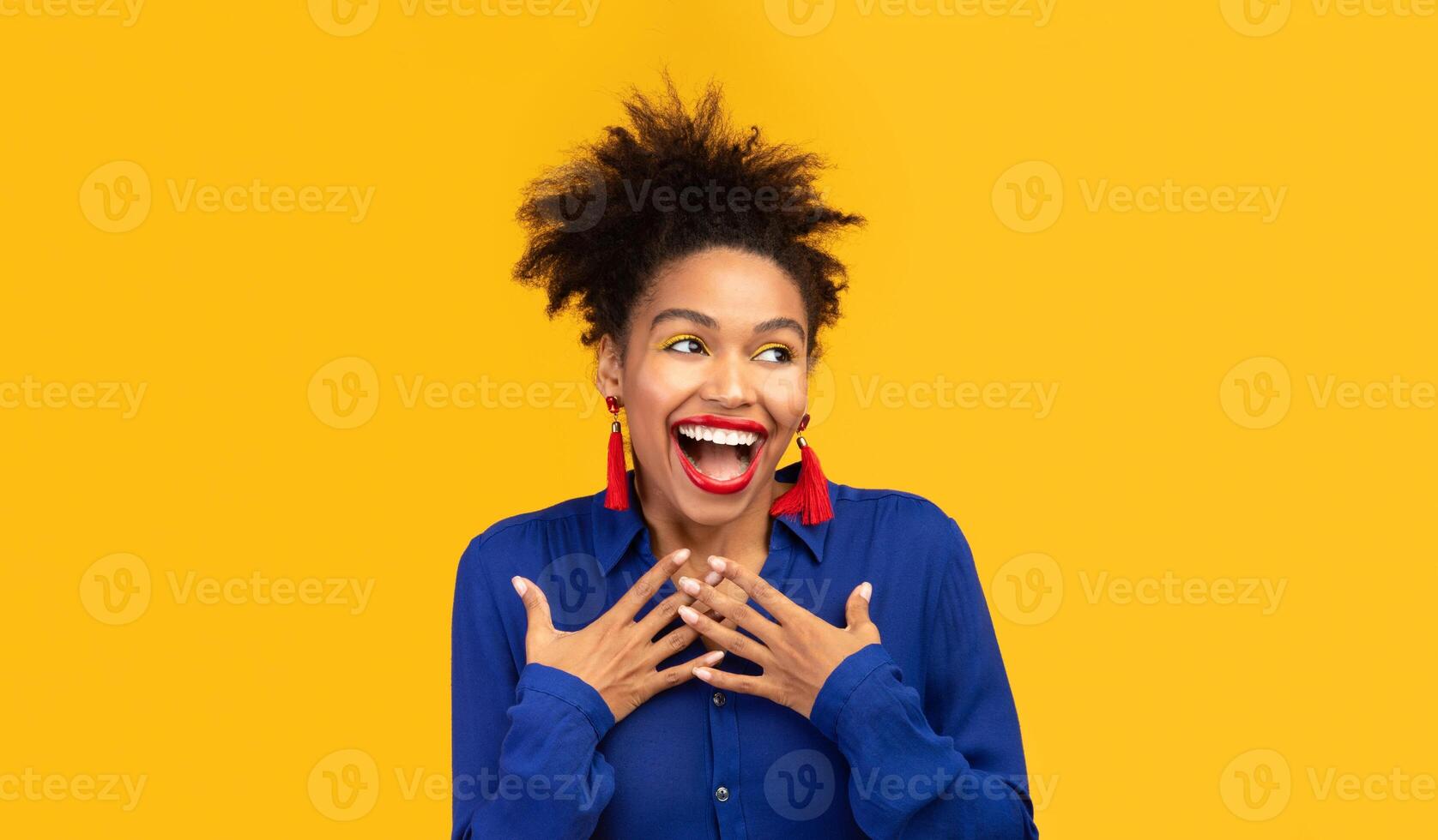 Who, Me. Headshot of young afro woman holding hands on her breast, looking aside at copyspace, orange wall photo