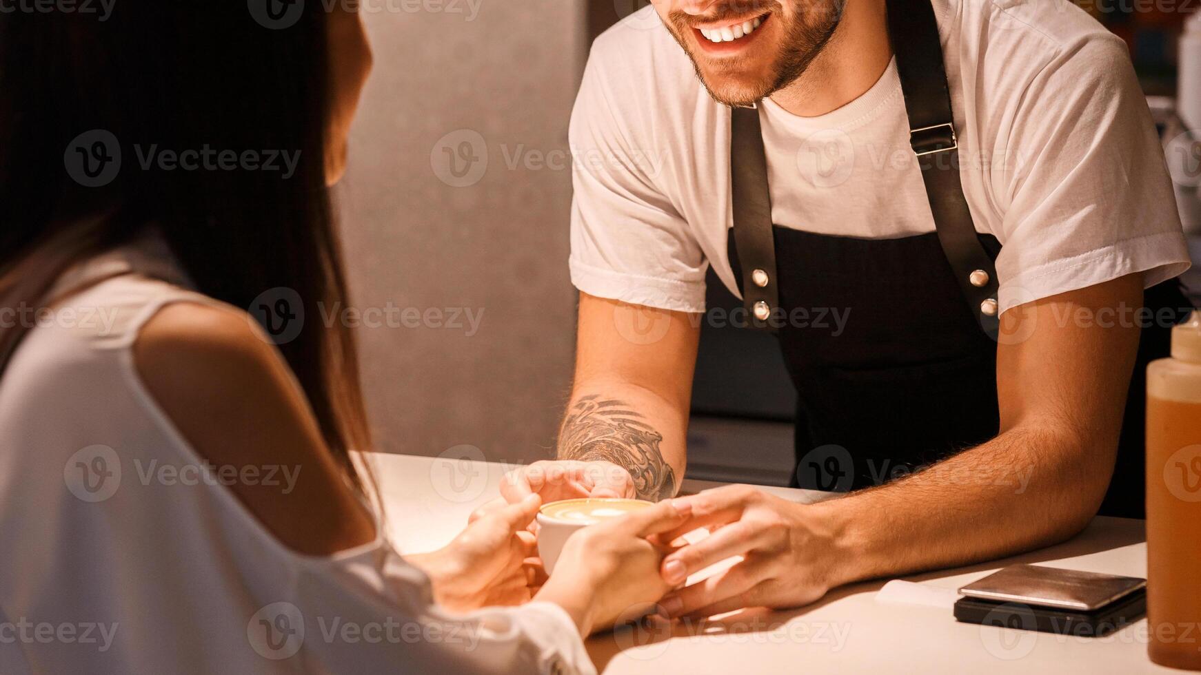 Barista Giving Coffee Flirting With Female Client Standing At Bar Counter In Cafe. Selective Focus photo