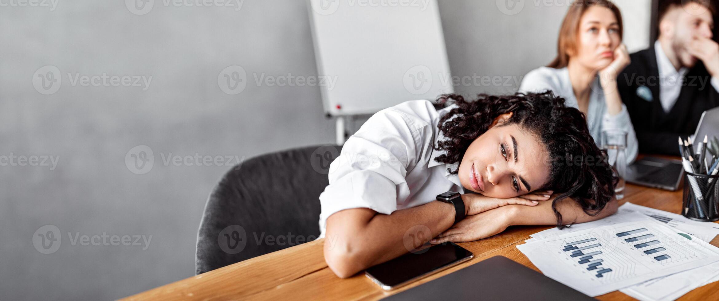 Boring Job. Depressed Business Lady Resting Head On Hands Uninterested In Work During Corporate Meeting In Office. photo