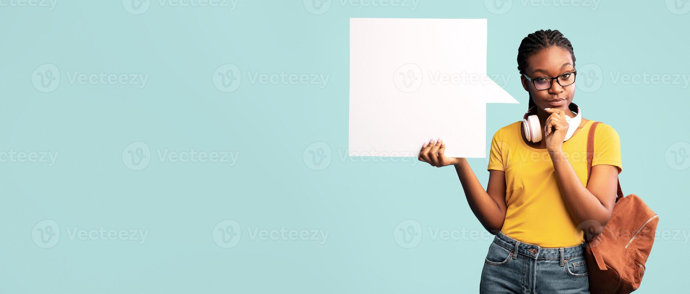 Thoughtful Black Student Lady Showing Empty Speech Bubble Thinking About Something Posing Over Blue Studio Background. Mockup photo