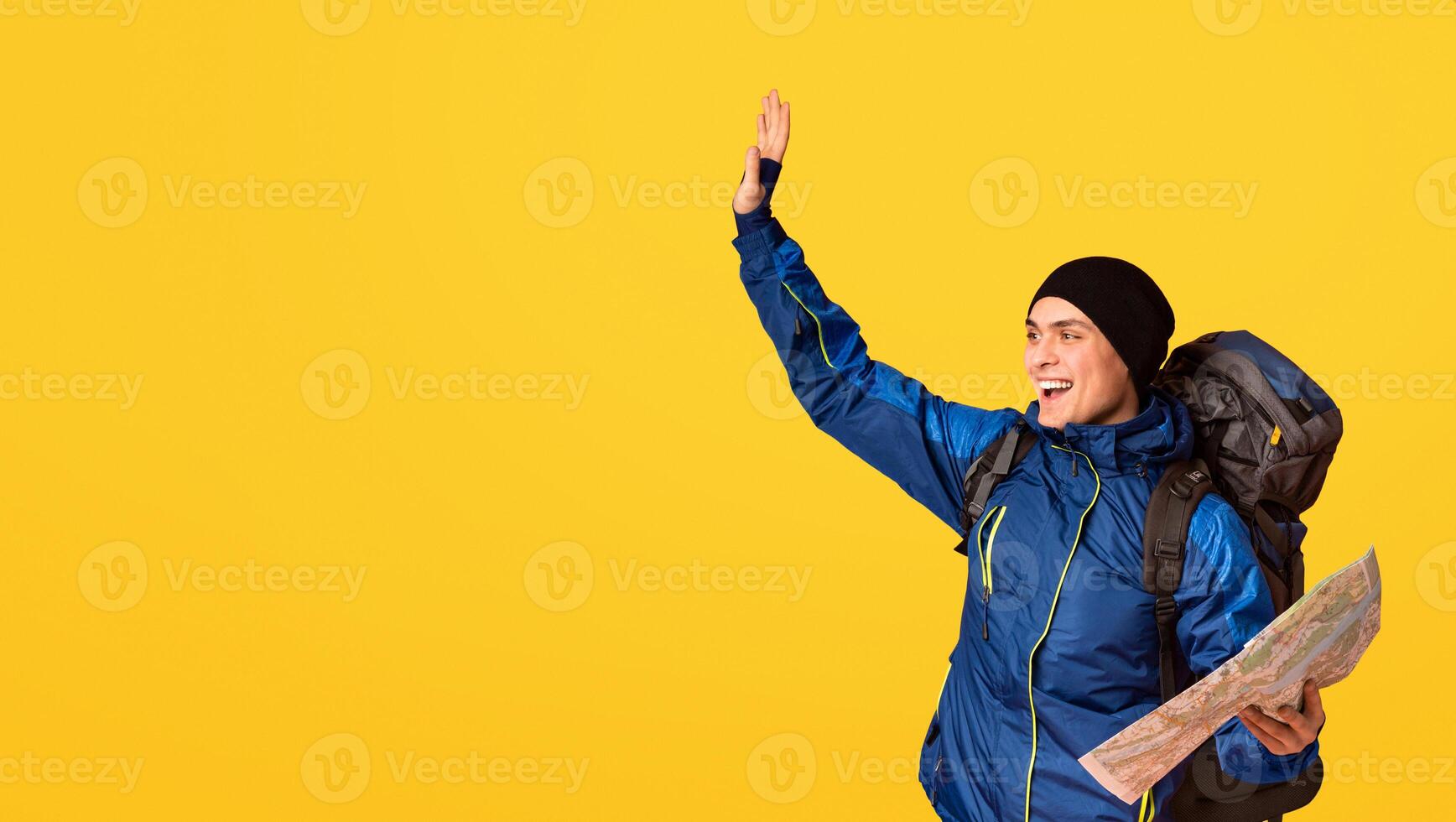 Happy backpacker with city map found a place, gesturing over orange background, looking at empty space photo