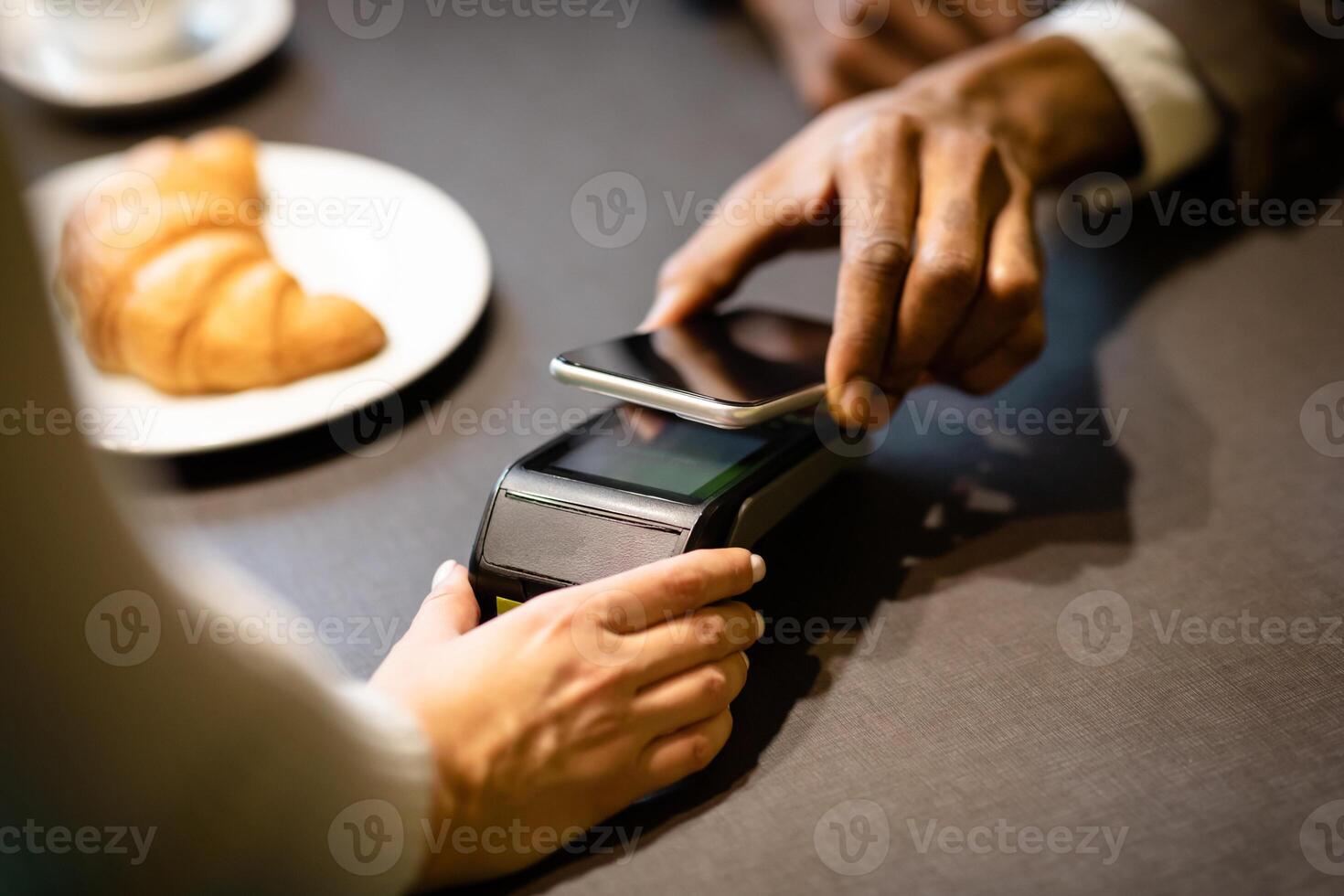 Wireless Pay. Afro Man Paying Via Cellphone In Modern Cafe, Copyspace photo