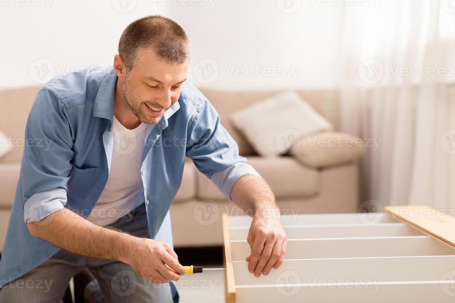 Happy Man Assembling Furniture Installing Shelf Making Renovation At Home. Selective Focus photo