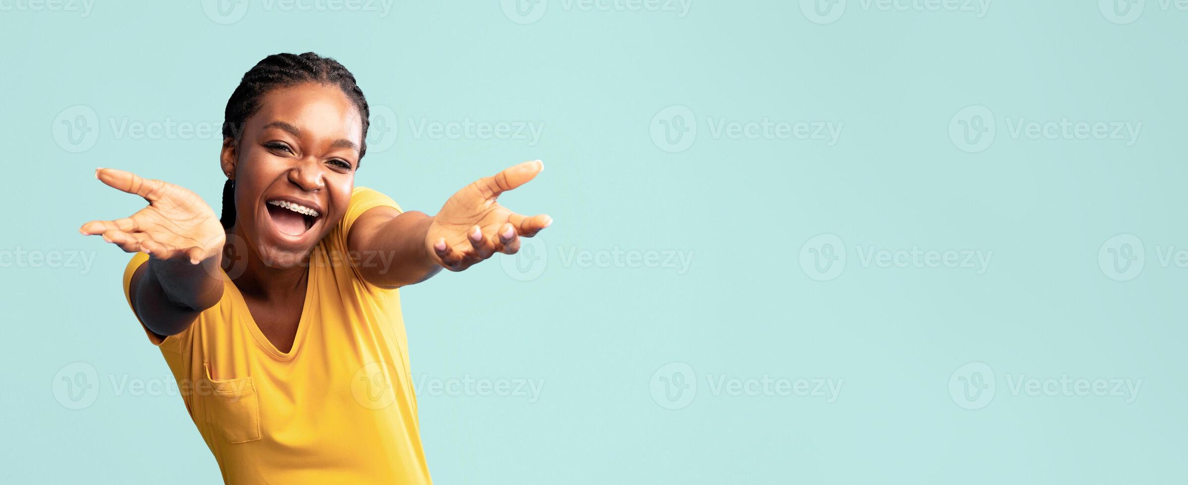 Give Me Hug. Joyful African Lady Stretching Hands To Camera Posing On Blue Background. Studio Shot photo