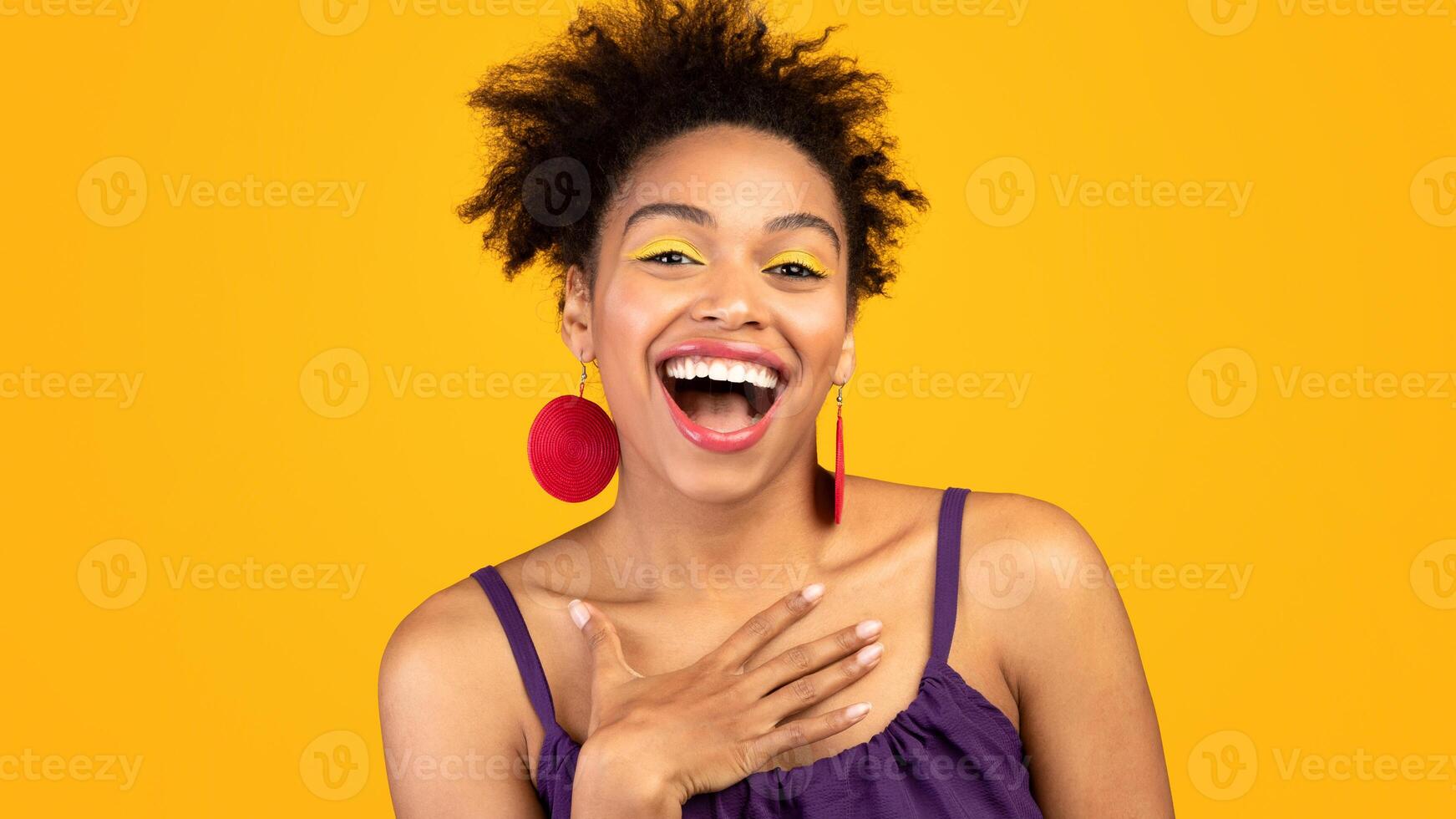 Sincere Human Emotions. Portrait of cute black girl laughing out loud over yellow studio wall, free space photo