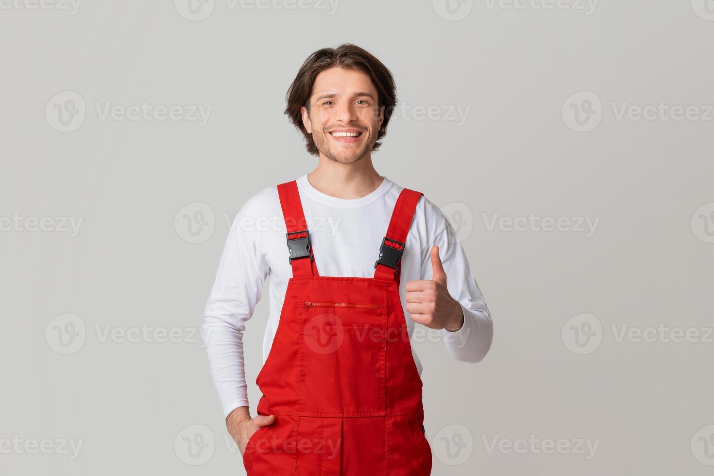 Handyman Services Concept. Portrait Of Smiling Young Workman In Uniform Showing Thumb Up, Panorama With Copy Space photo
