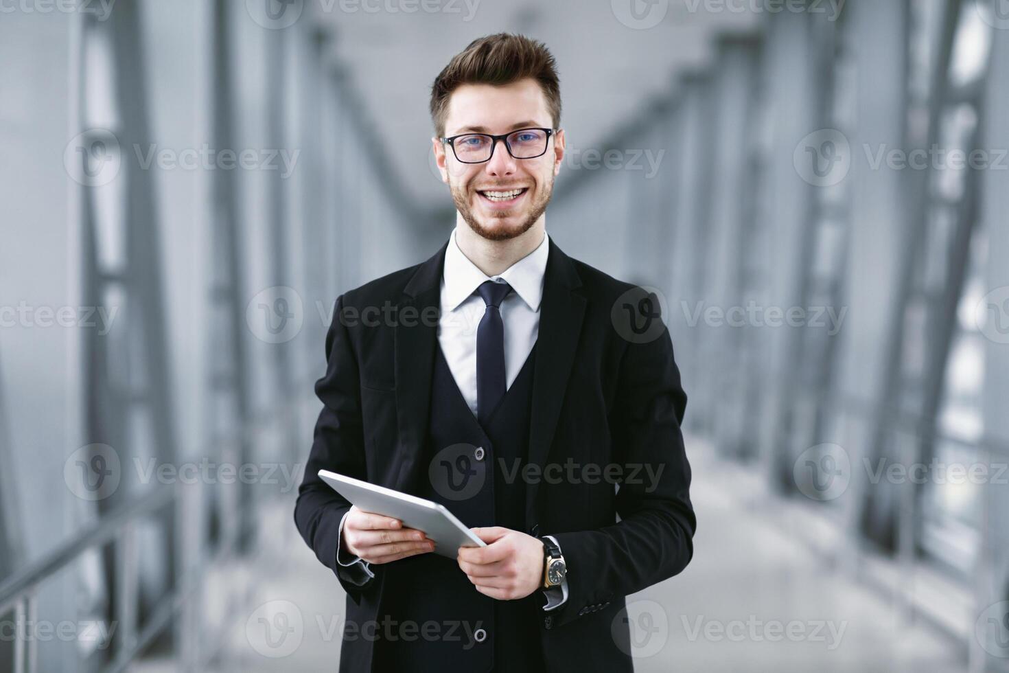 Successful Executive. Handsome bearded businessman in specs holding digital tablet and looking at camera photo