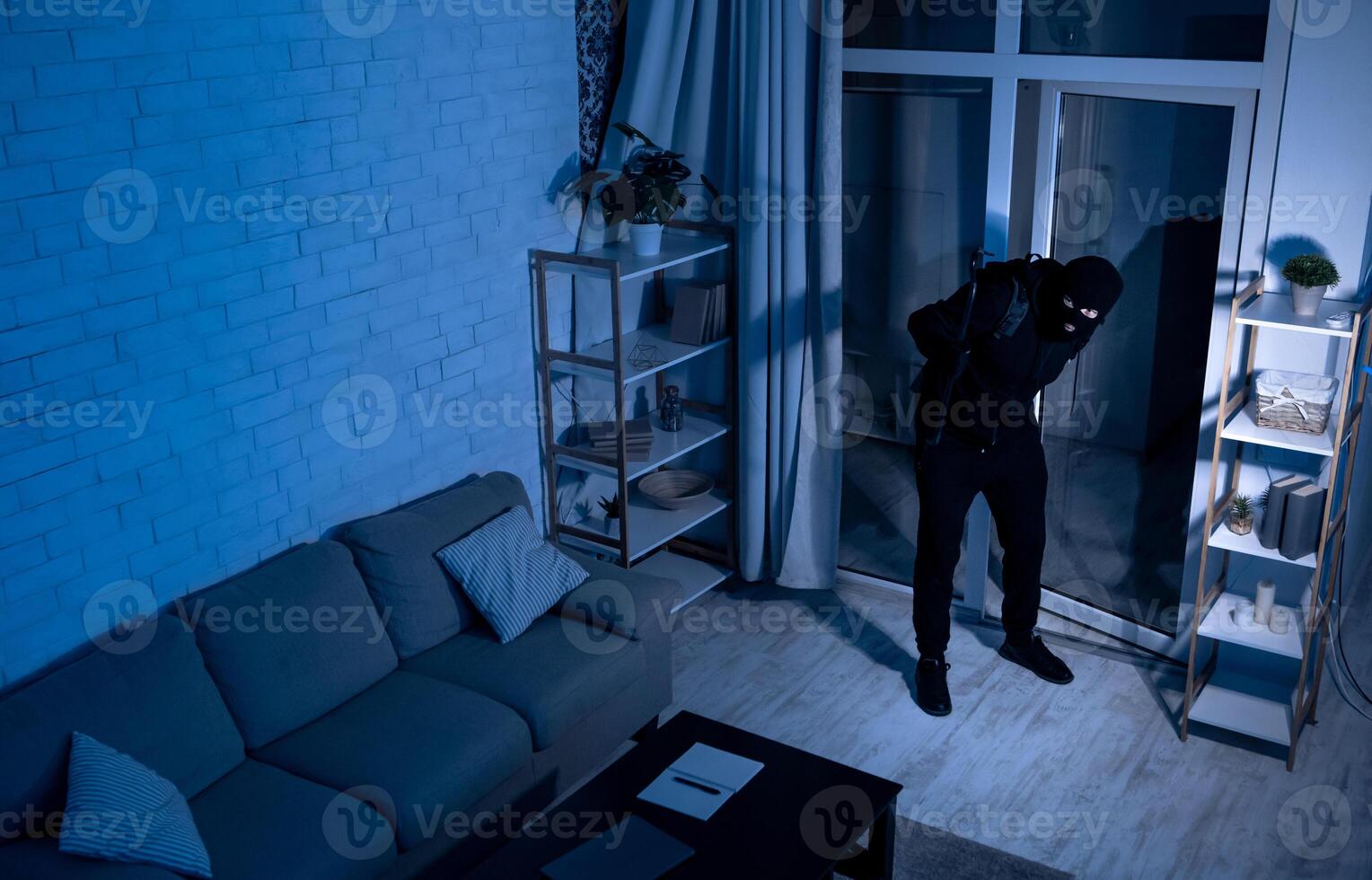 Housebreaking Concept. Intruder sneaking into house at night, holding crowbar, top view from above camera, high angle photo