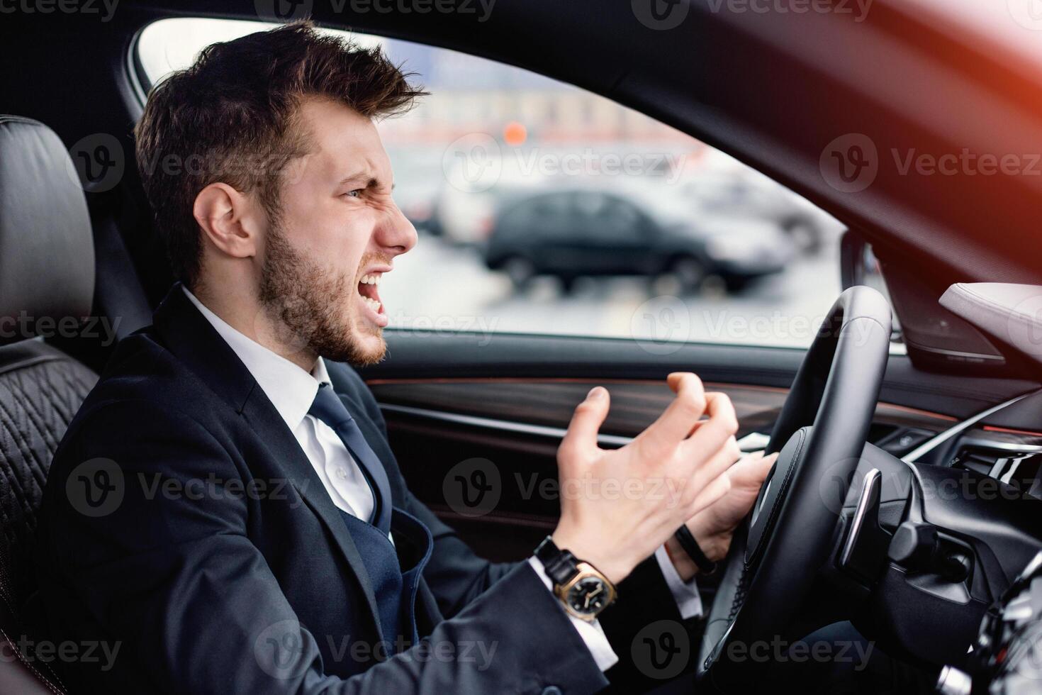 Angry Driver Concept. Aggressive mad man in suit driving car in urban city, angrily gesturing photo
