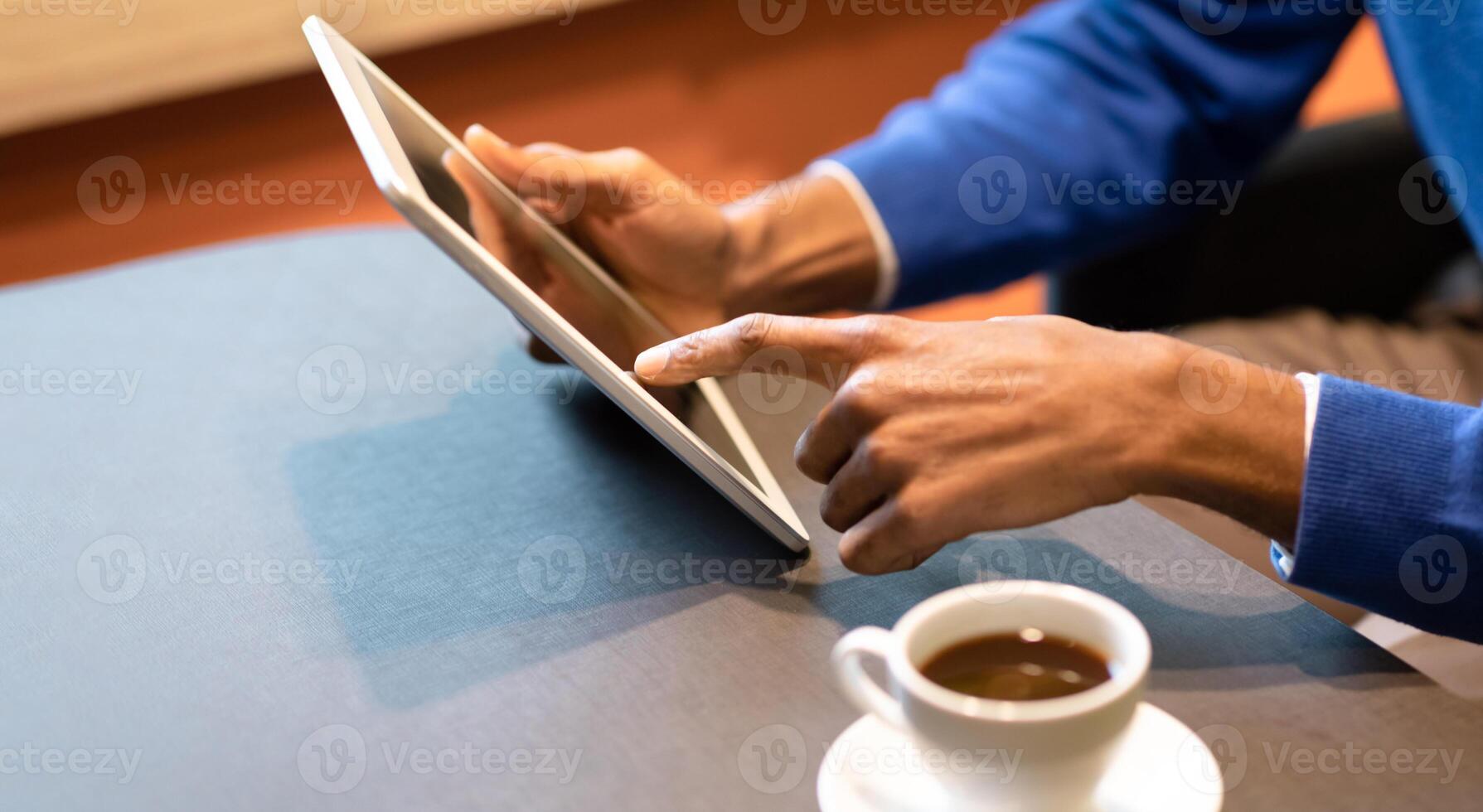 Reading News. Unrecognizable afro guy holding digital tablet device computer at coffee shop, copyspace photo