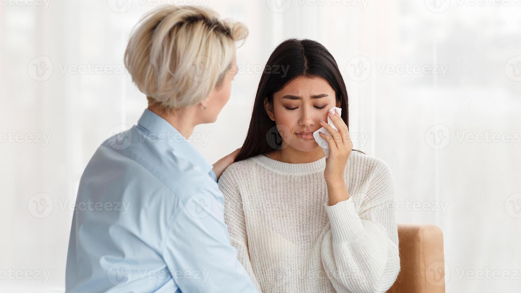 Couples Therapy. Professional Psychologist Comforting Unhappy Crying Wife During Family Therapy Appointment Sitting On Couch In Office photo