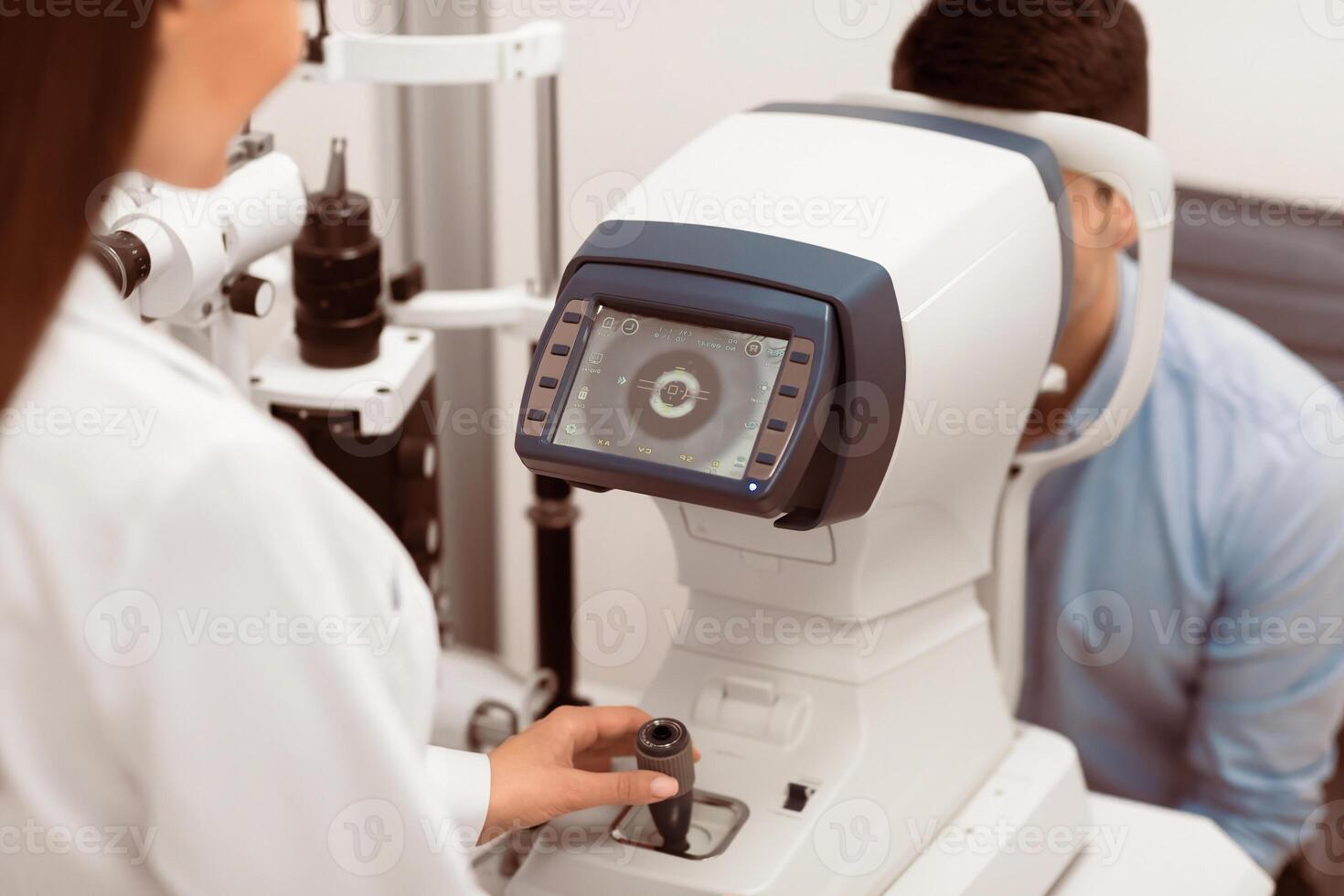 Eye Inspection Concept. Lady ophthalmologist checking eye vision of young male customer in modern clinic, back view photo
