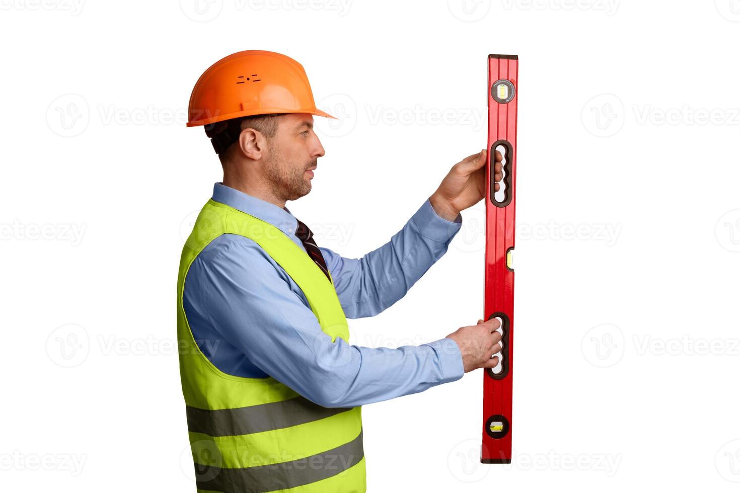 Professional Builder Holding Building Level Working Standing Over White Background In Studio, Wearing Orange Uniform And Helmet. Construction Tools Concept. Side View photo
