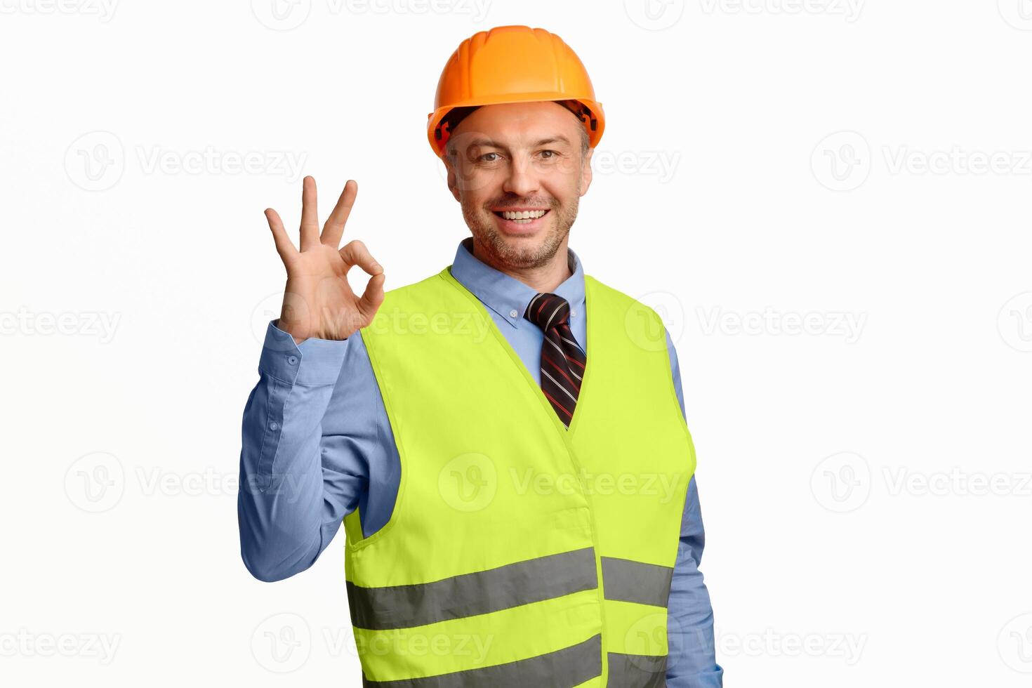 Building Is Okay. Construction Site Worker Gesturing Ok Posing Over White Studio Background, Smiling To Camera photo