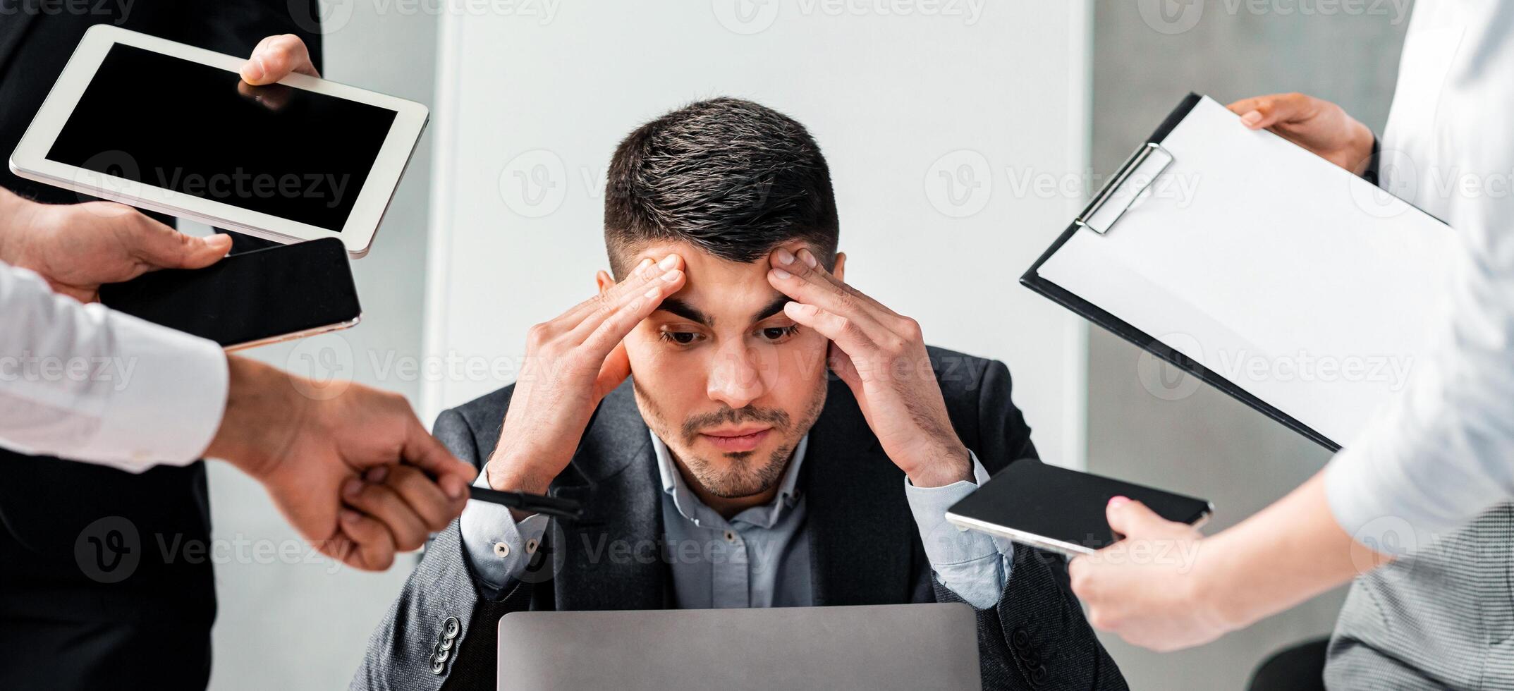 Multitasking Concept. Overworked Businessman Sitting At Laptop Overloaded With Work Multiple Tasks In Modern Office. photo