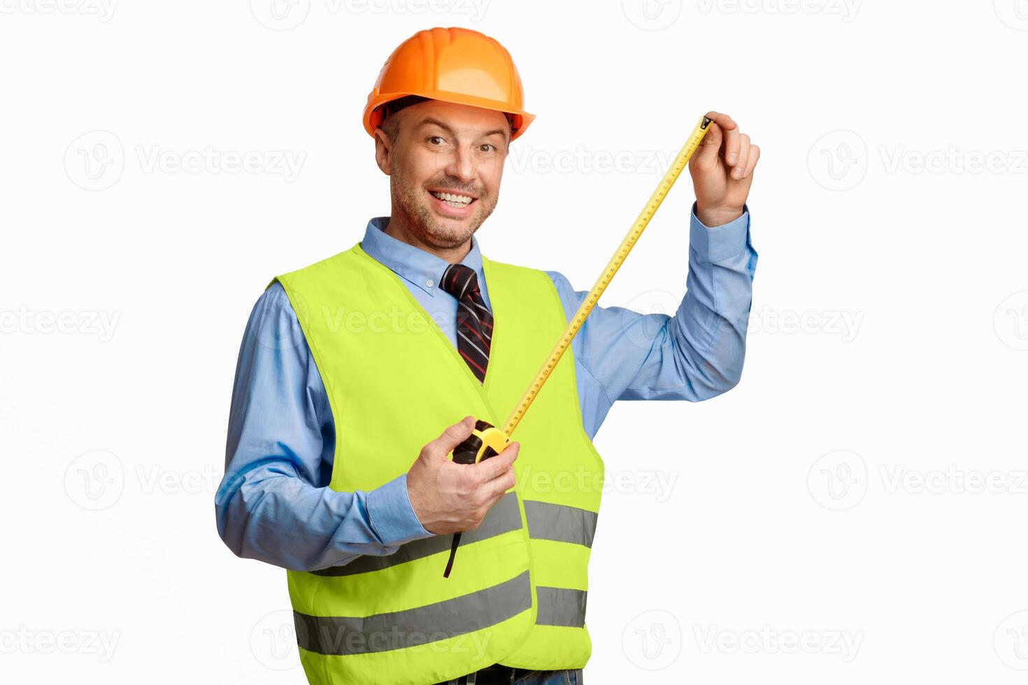 Builder Workman Posing With Tape-Measure Smiling To Camera Standing On White Background. Building House Concept. Studio Shot photo