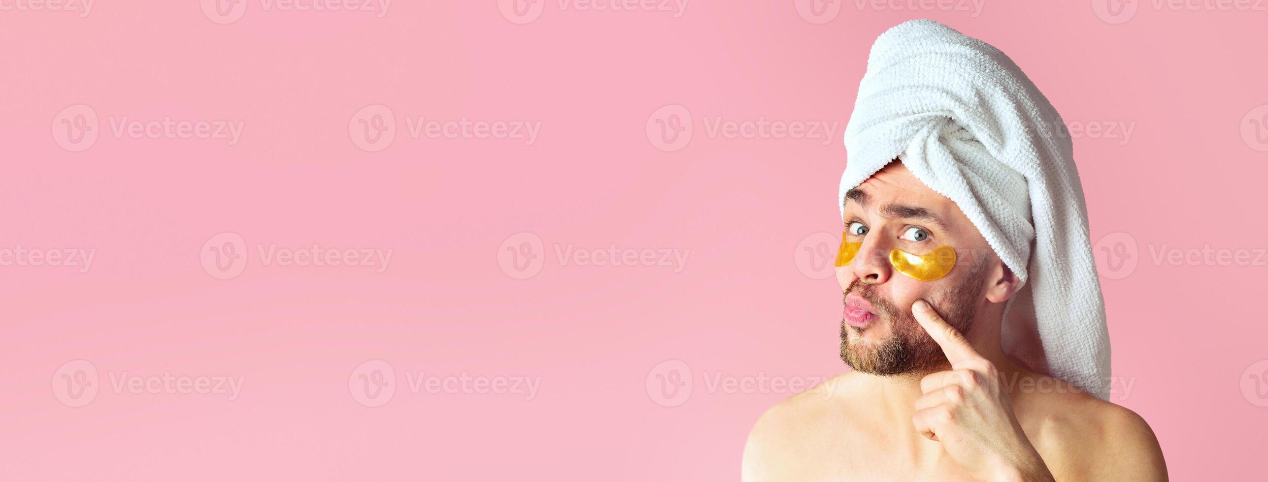 Funny guy with towel on head looks in mirror at patches for eyes photo