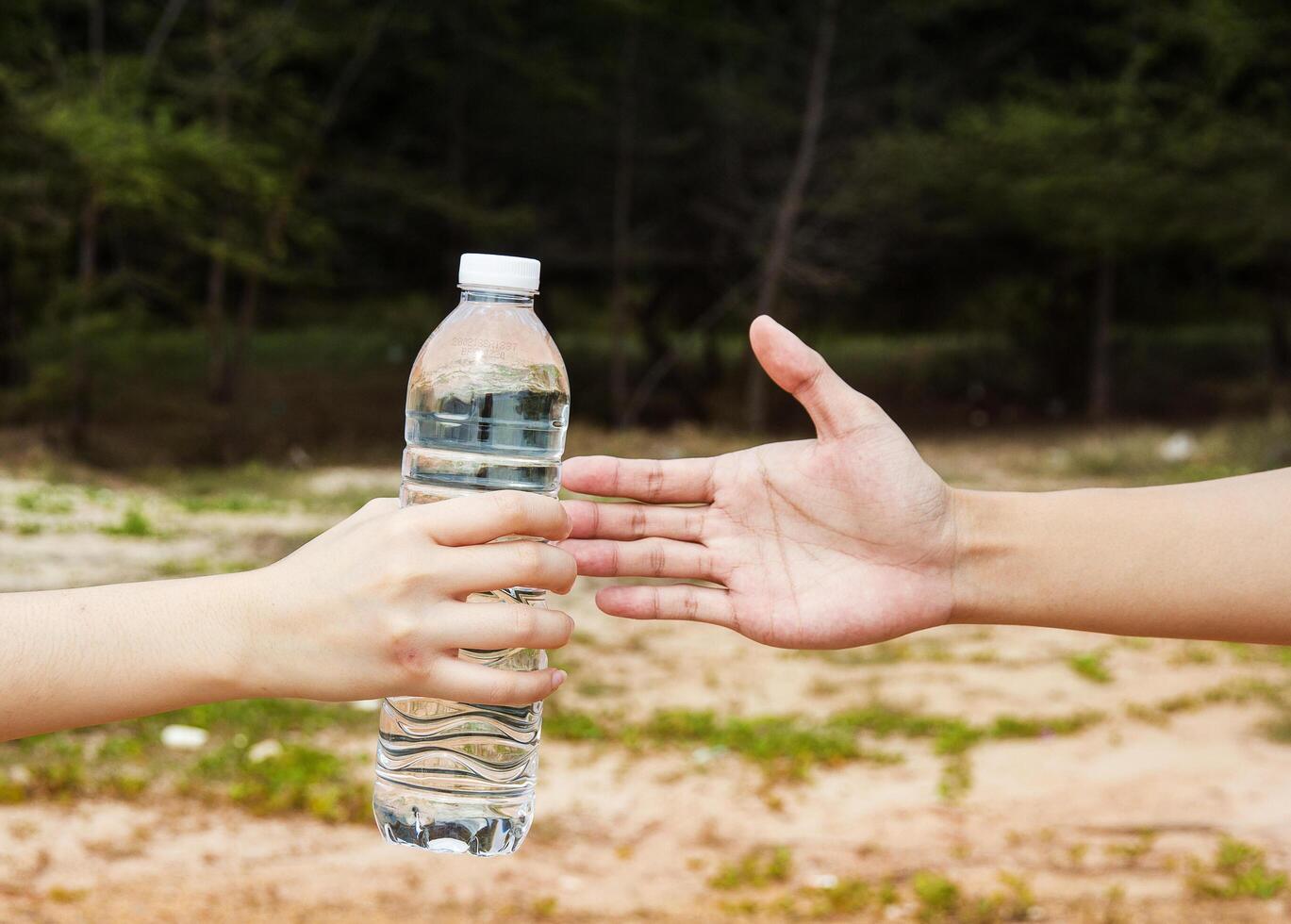 hands send water bottle together,gave and give concept. photo