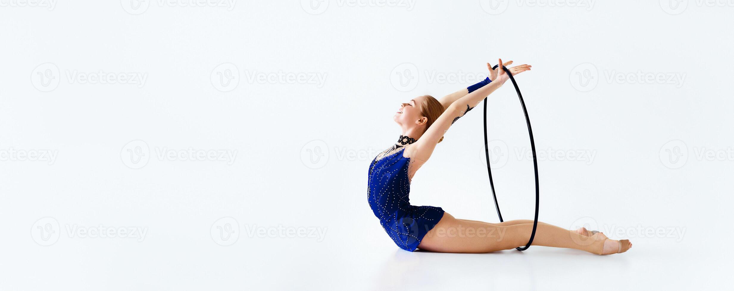Gymnastic performance. Slim athletic girl in bright costume working out with hoop on white background, copy space photo