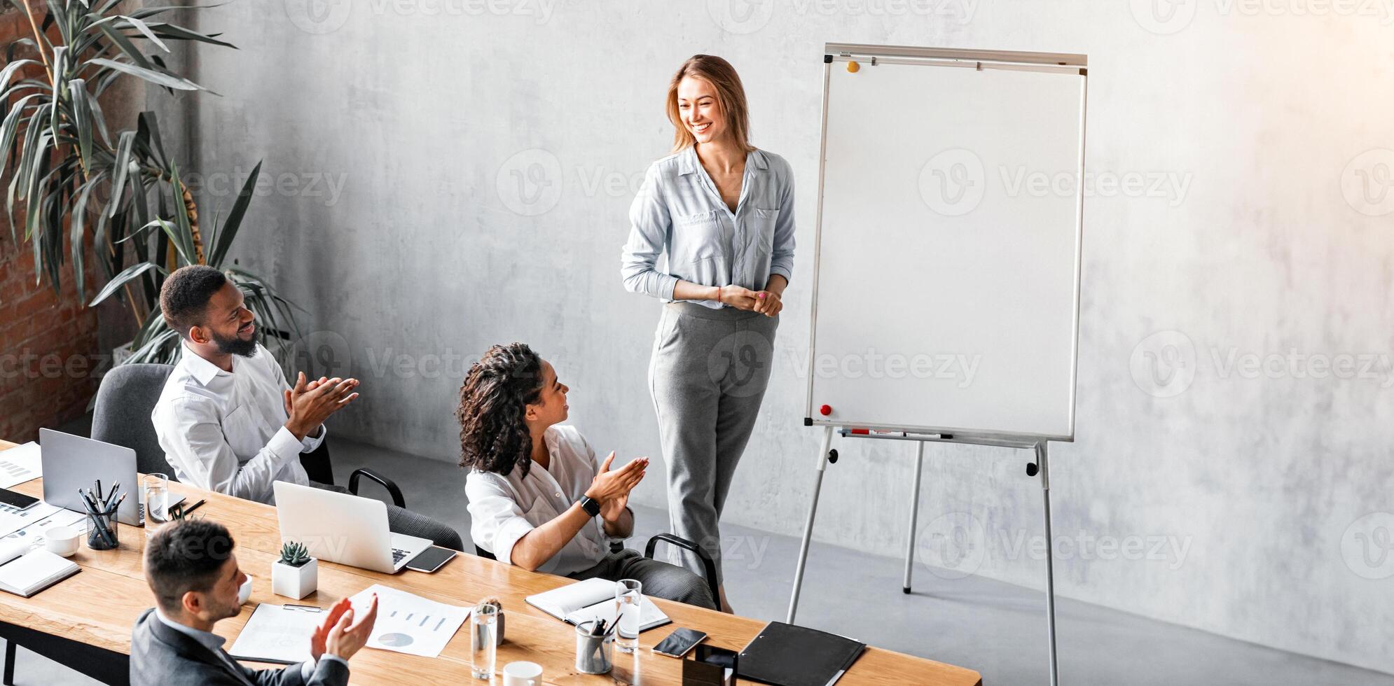 Successful Business Presentation. Coworkers Giving Speech Presenting New Idea To Colleagues Standing Near Blackboard In Modern Office. Free Space photo