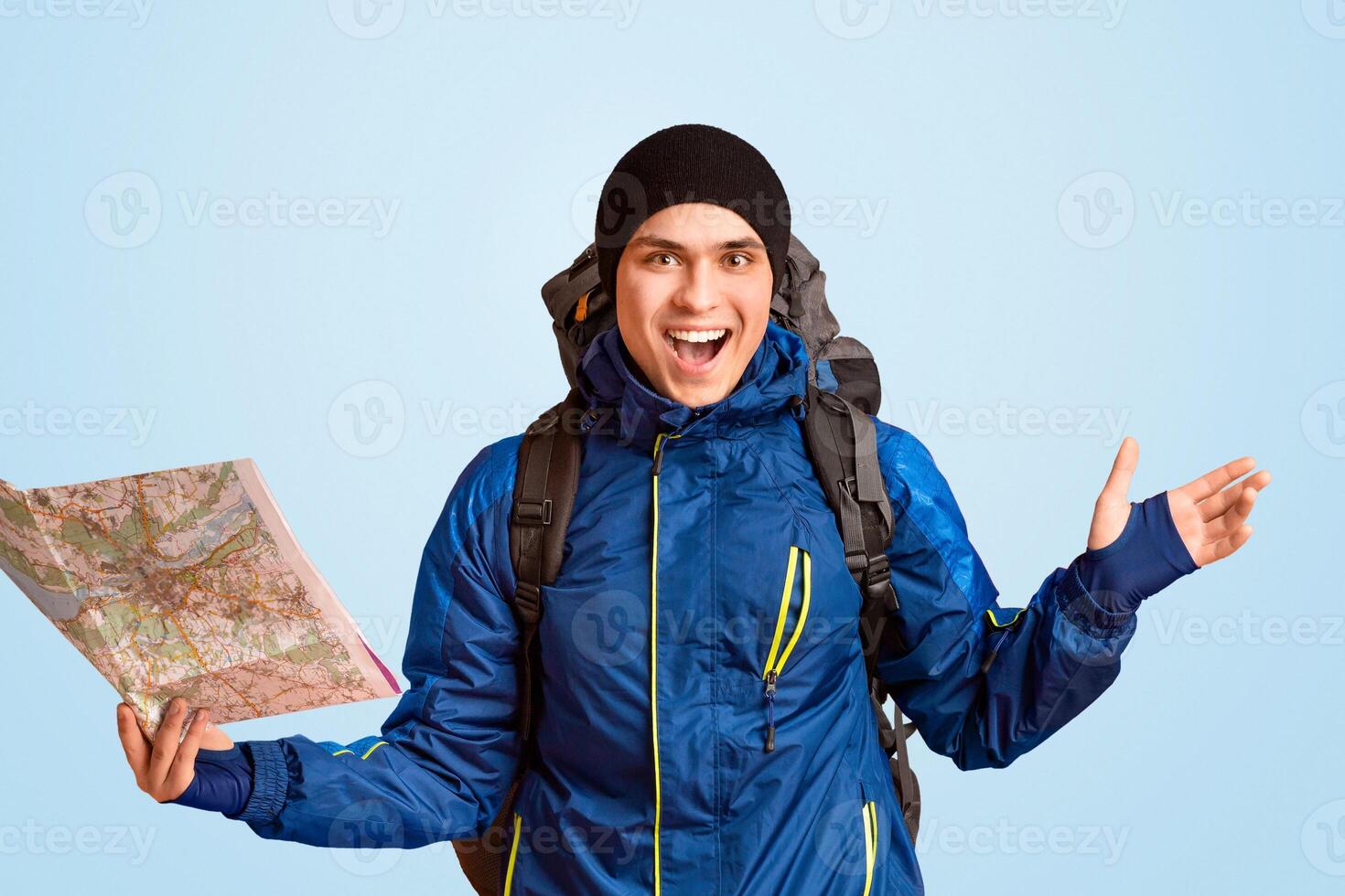 Emotional guy backpacker with map in hand exclaiming happiness, orange background photo