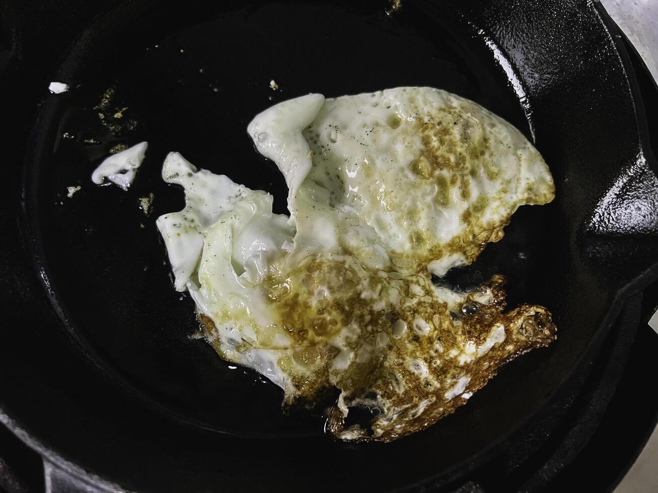 Fried egg yolk in black pan,on the stove photo
