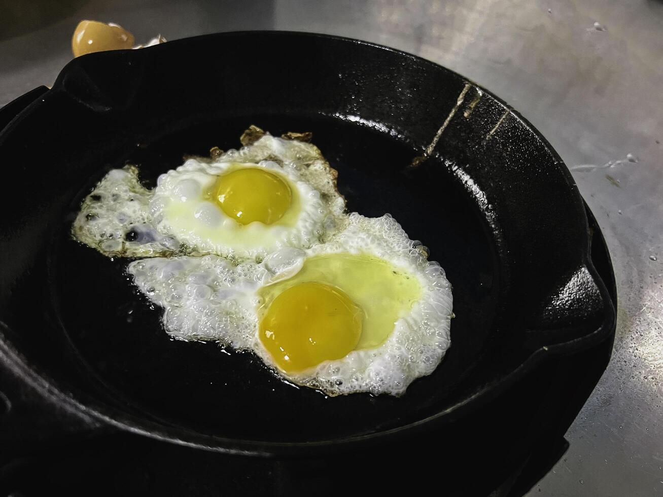 Fry the egg in cast iron pan,on the stove, photo
