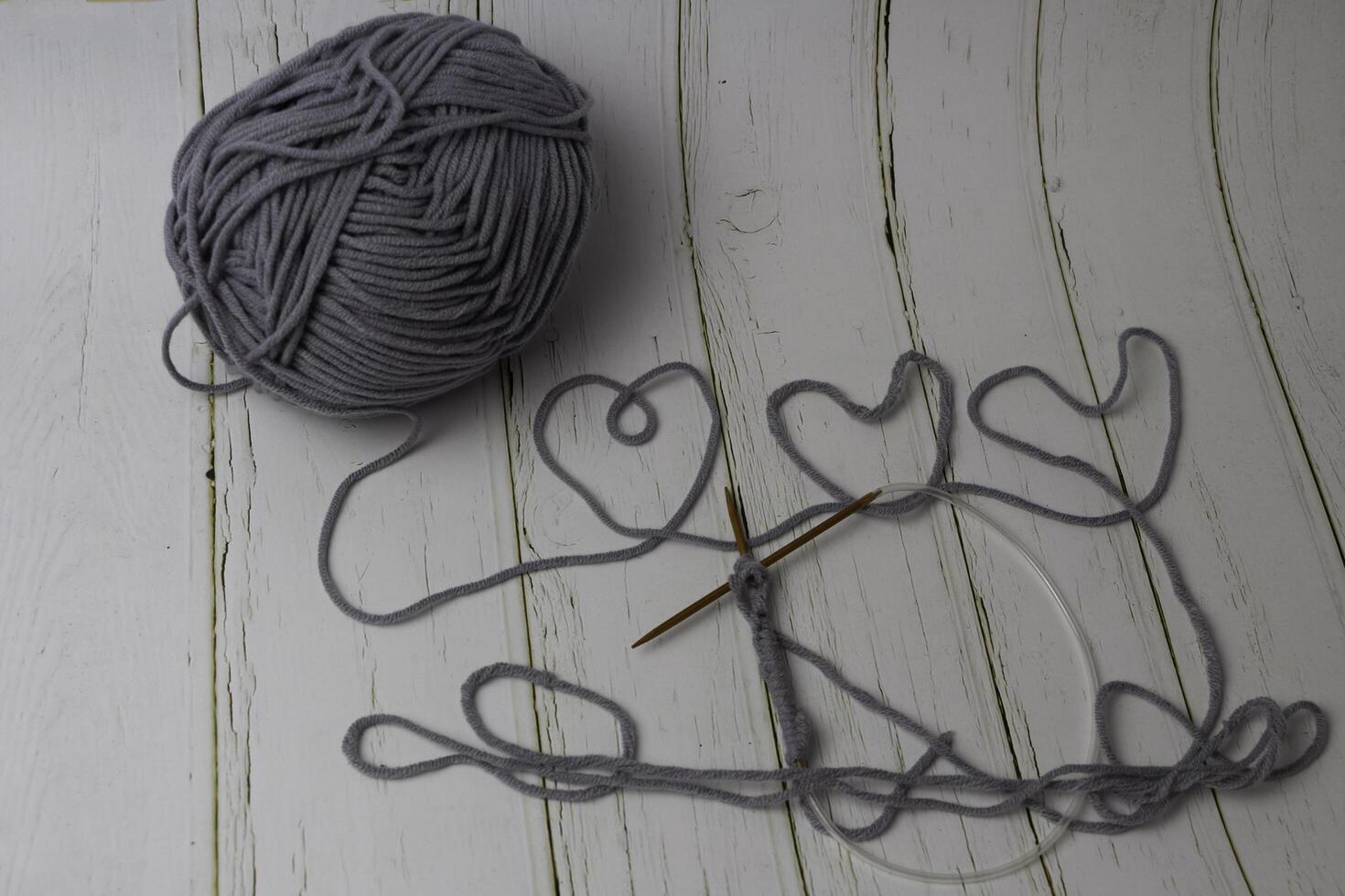 Knitting work with wood crochet hook put beside cotton thread, photo