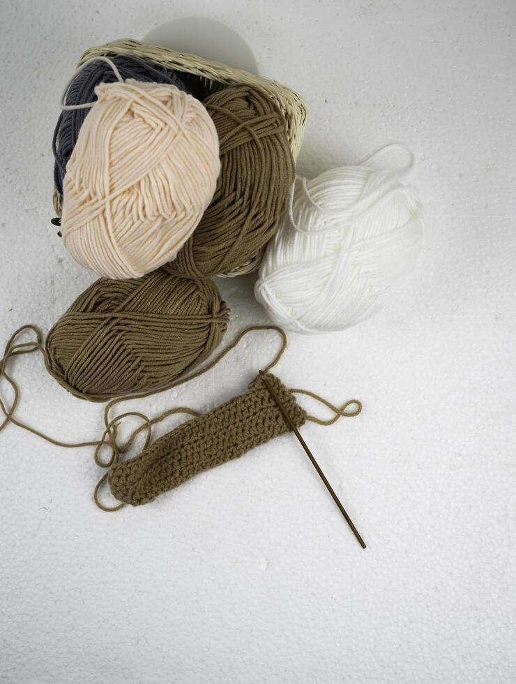 Top view of Crochet work with wooden crochet hook and brown yarn ball, photo
