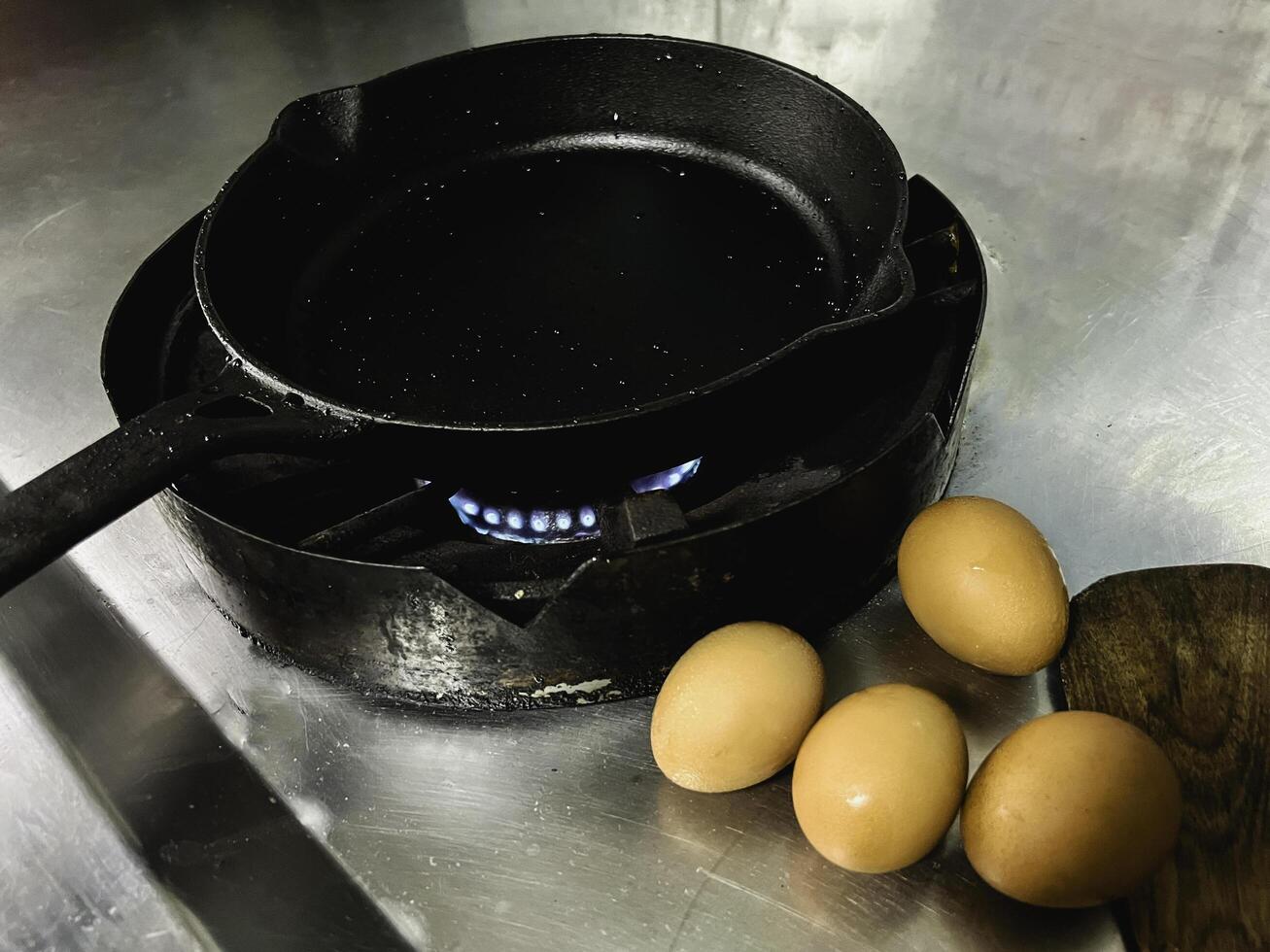 Cast iron pan wet from oil spray put on the stove,black color,prepare for cooking photo