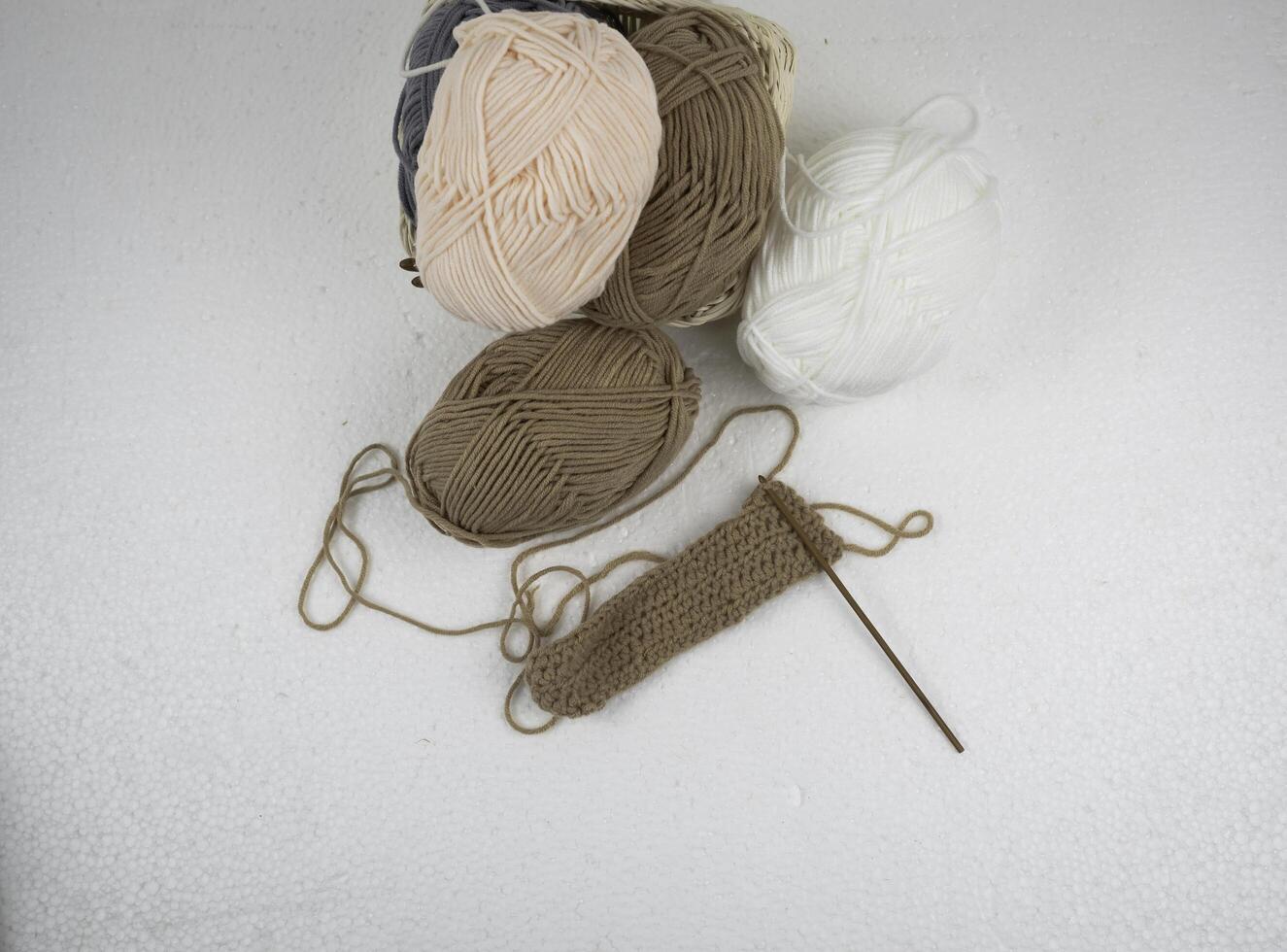 Top view of Crochet work with wooden crochet hook and brown yarn ball, photo