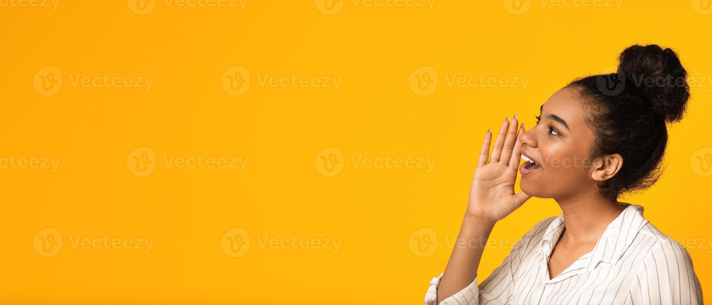 Announcement. Excited african american woman shouting at copy space, keeping hand near mouth, yelling over yellow background, long shot, panorama photo