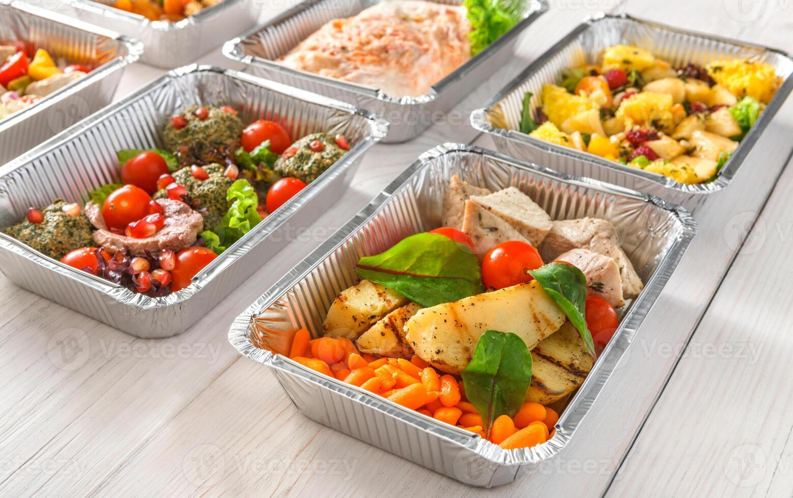 Healthy food background. Take away of natural organic meals in foil boxes. Fitness nutrition, meat, fresh salads, fruits and vegetables. Restaurant dishes delivery photo