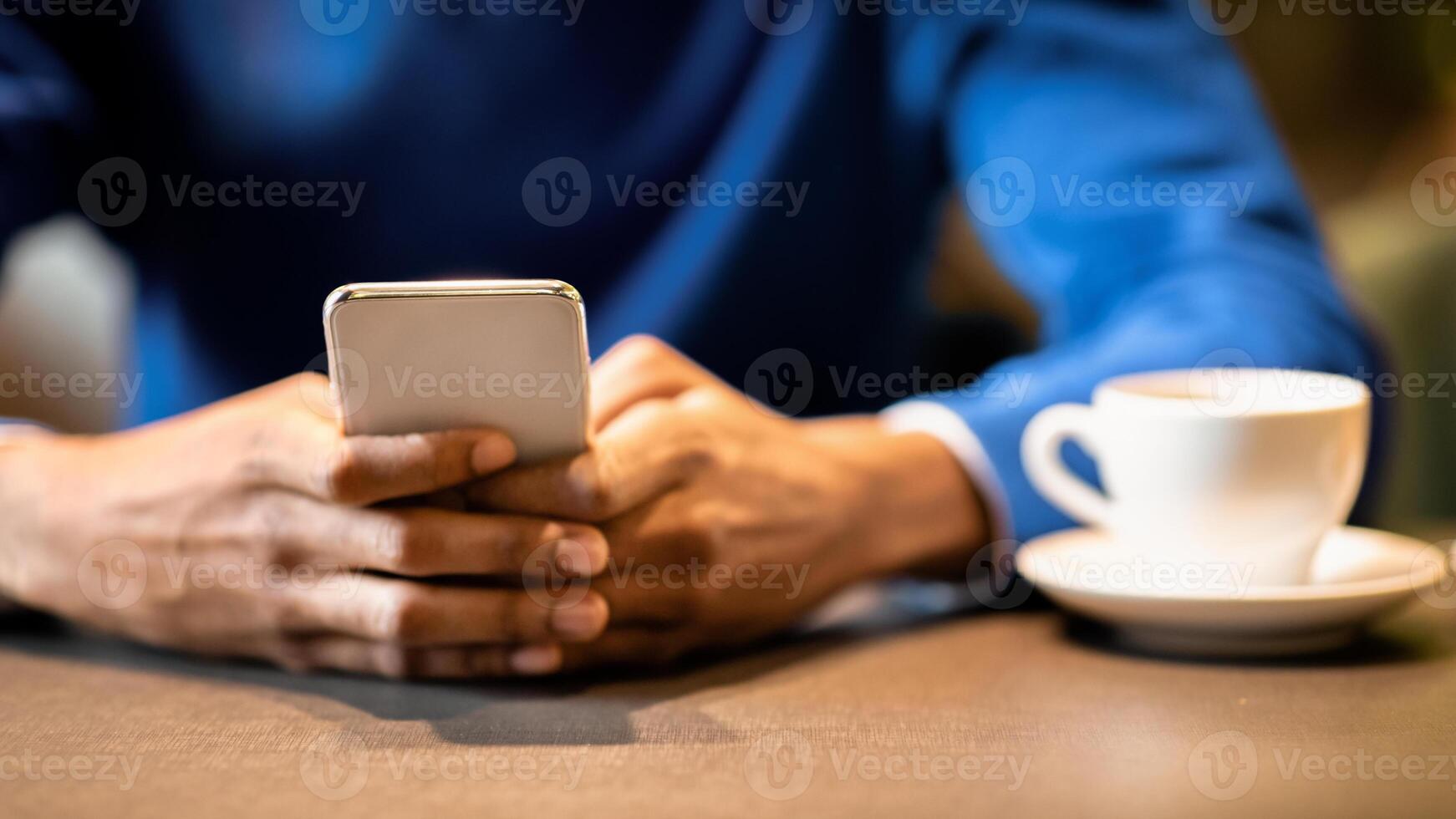New Useful Application. Unrecognizable black man using cellphone sitting at table in cafe, having coffee photo