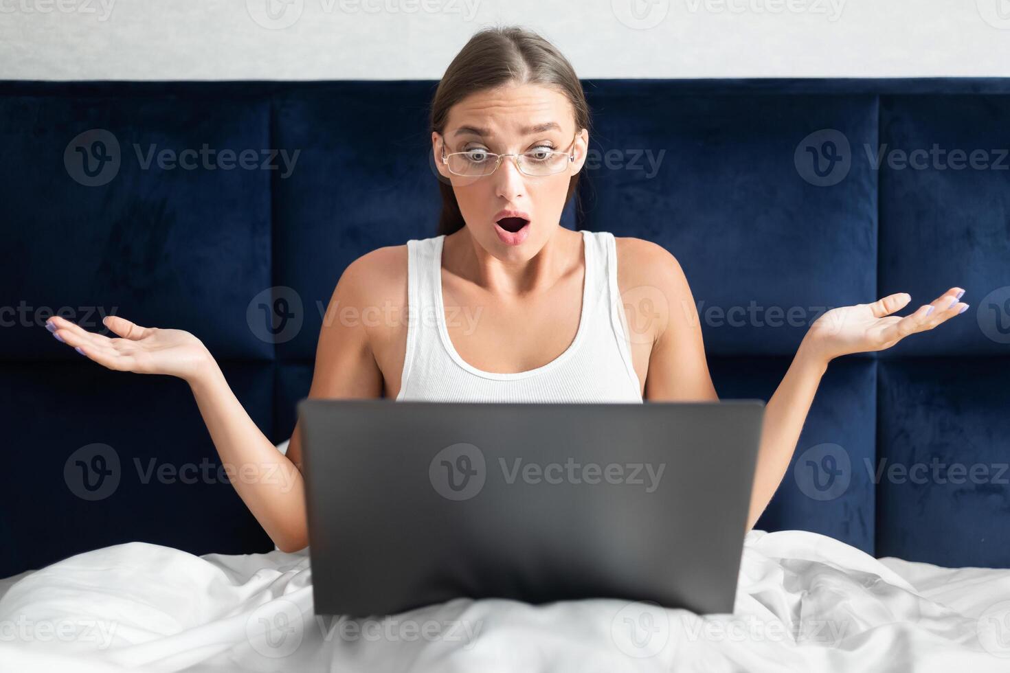 Shocked Girl Having Internet Connection Problem Working On Laptop Sitting In Bed At Home During Coronavirus Quarantine. Selective Focus photo