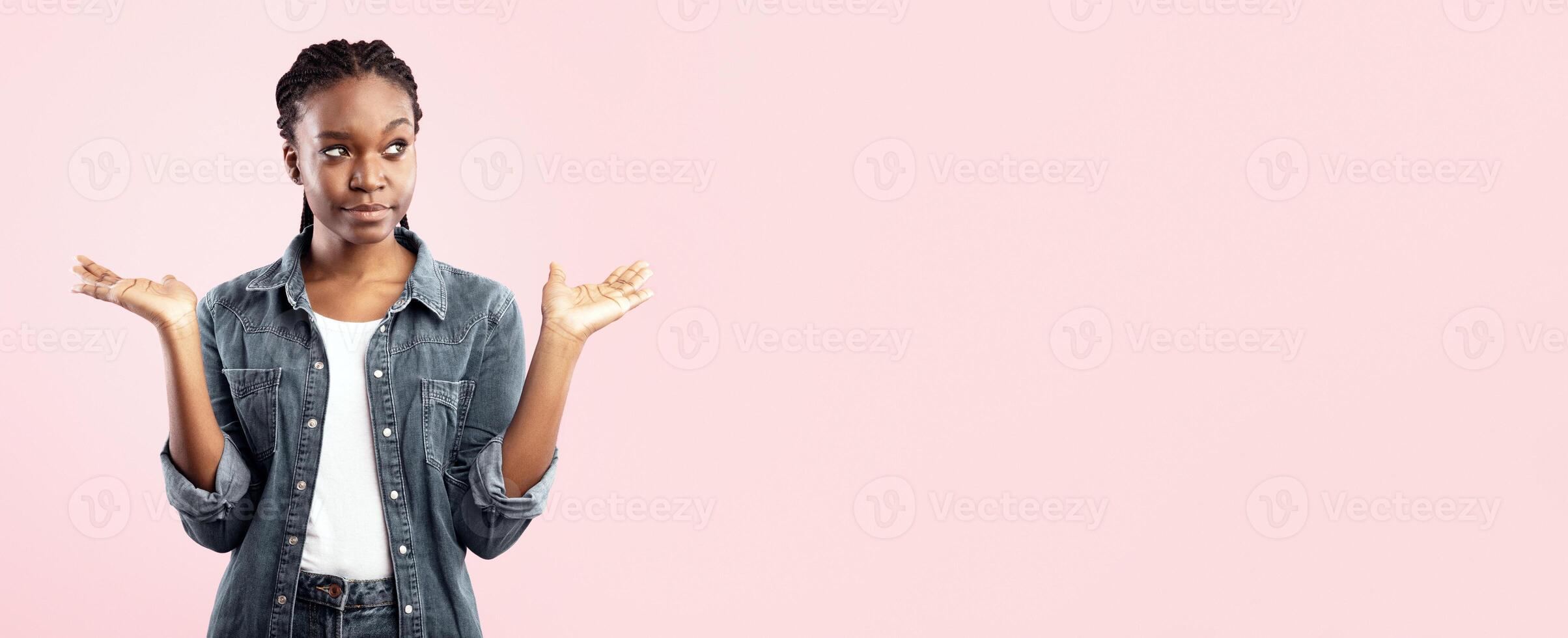 Choice Concept. Puzzled Black Lady Holding Two Invisible Objects Choosing Between Them Posing Over Pink Studio Background. Panorama, Empty Space photo