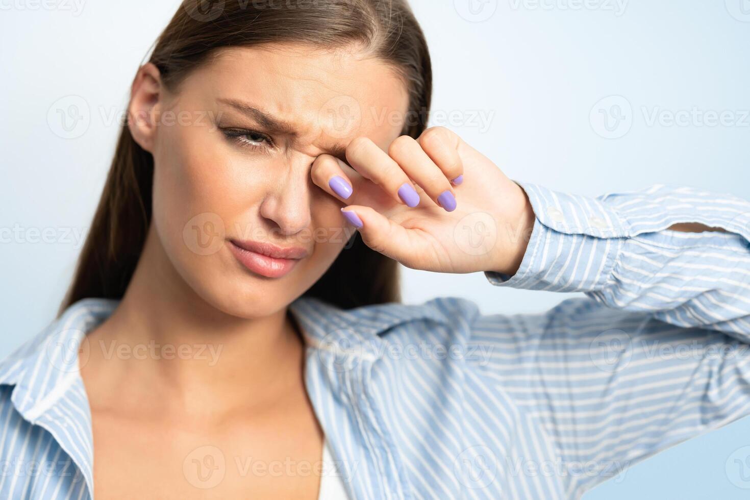 Coronavirus And Conjunctivitis. Woman Touching Aching Eye Having Covid-19 Symptoms Standing On White Background. Studio Shot photo