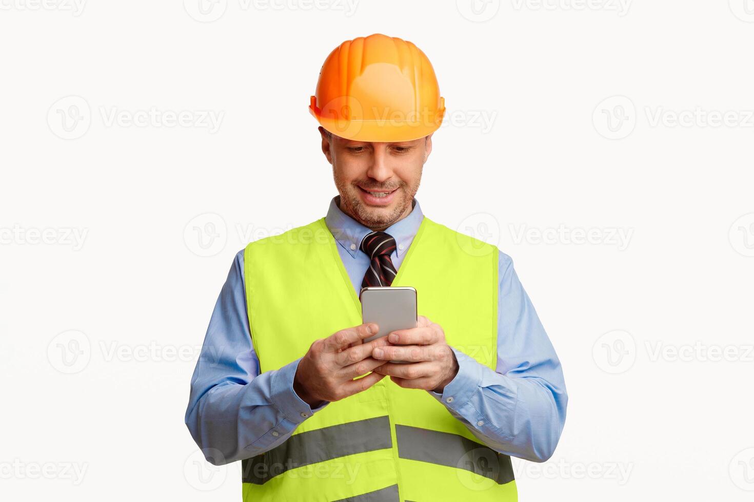 Construction Worker Using Smartphone Application Standing On White Studio Background. Mobile App Concept photo