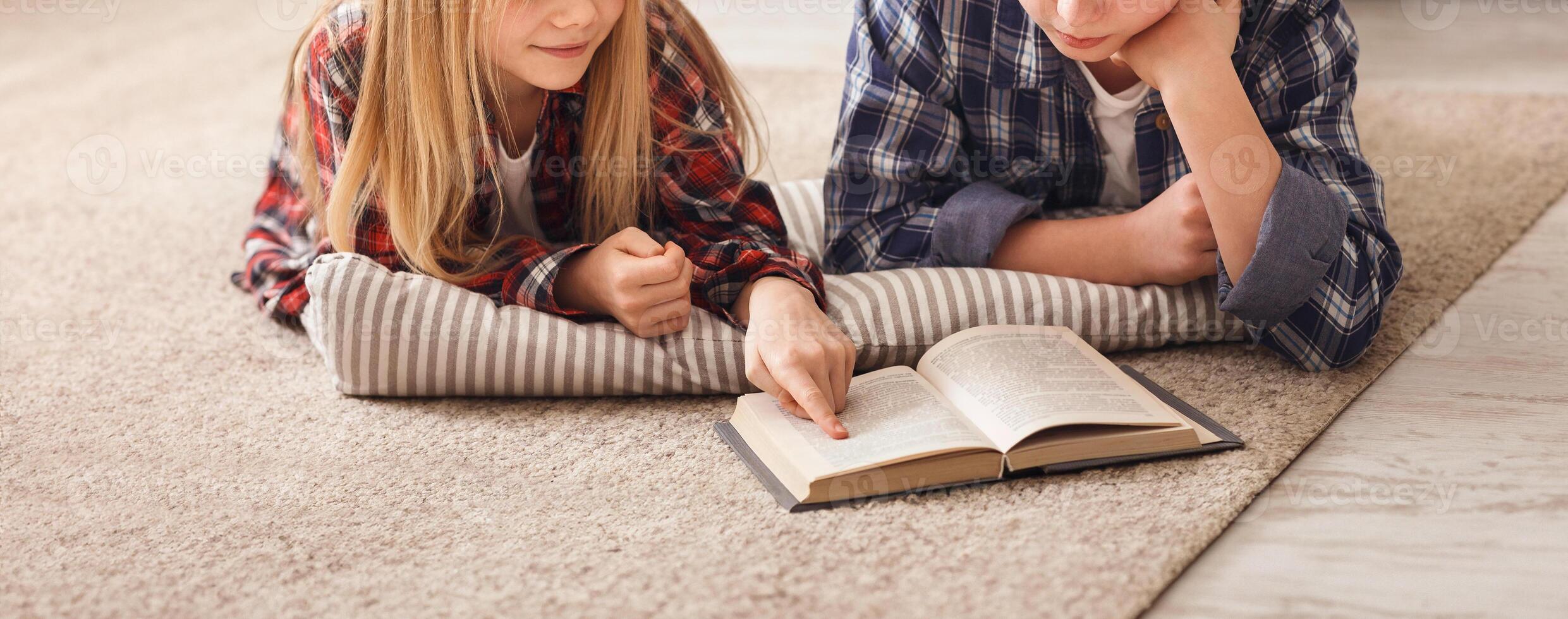 Brother And Sister Reading Book Together Doing Homework Lying On Floor At Home On Weekend. Best Friends. photo