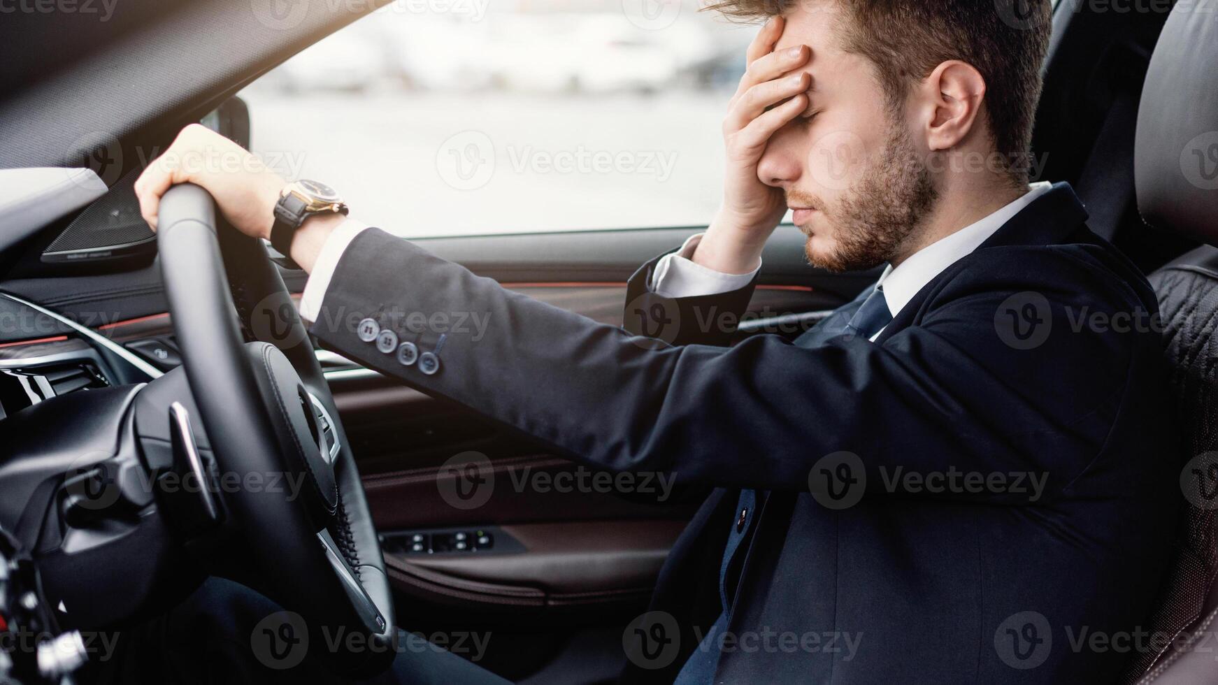 Fatigue Concept. Exhausted manager in despair driving car, having headache, feeling stressed photo