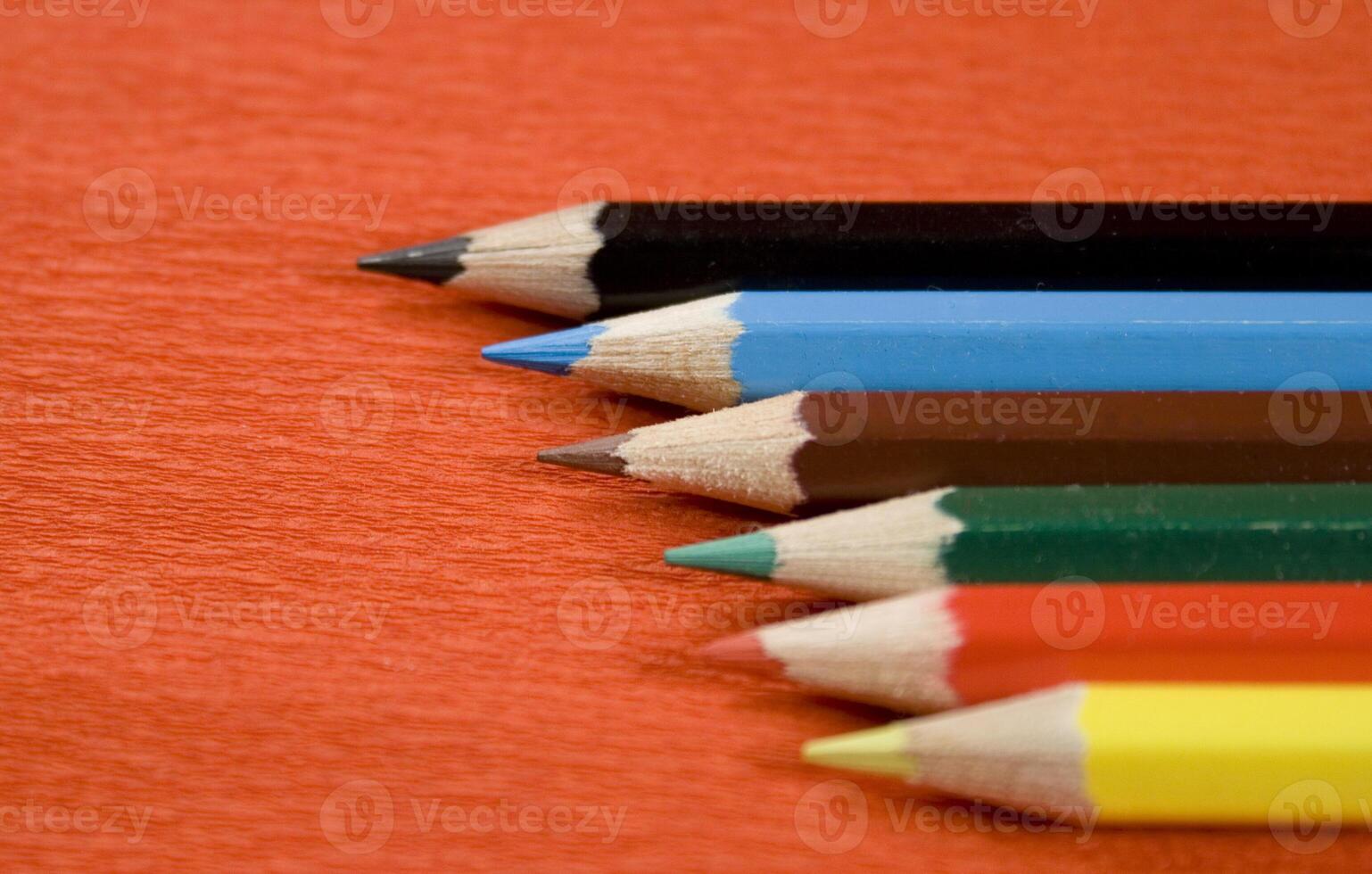 coloured pencils on red background photo