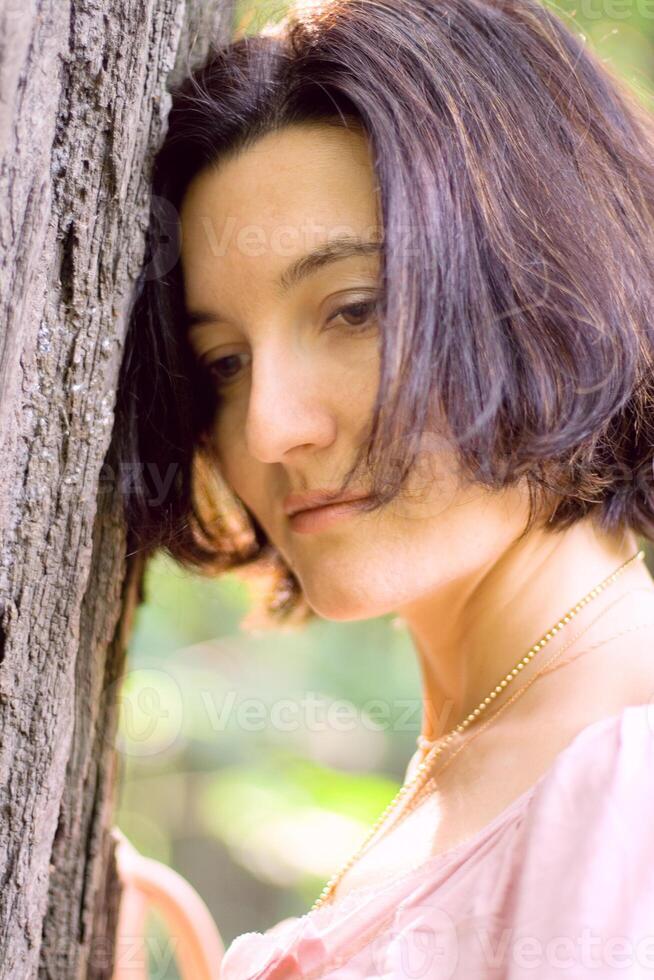 unhappy woman near the tree photo