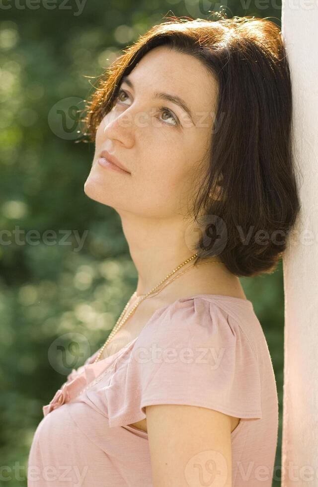 pretty woman standing near white column photo