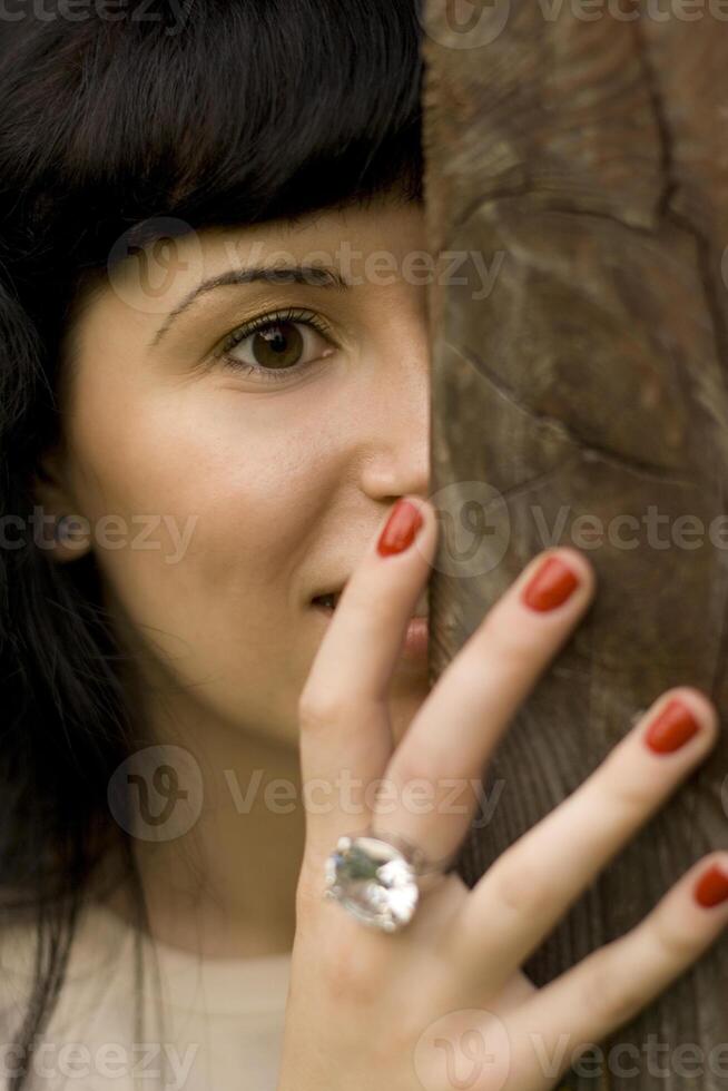 girl hiding behind a tree photo