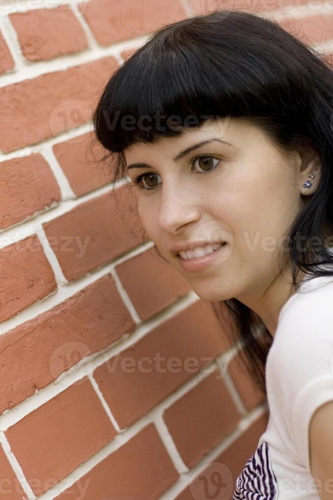 girl against brick wall photo