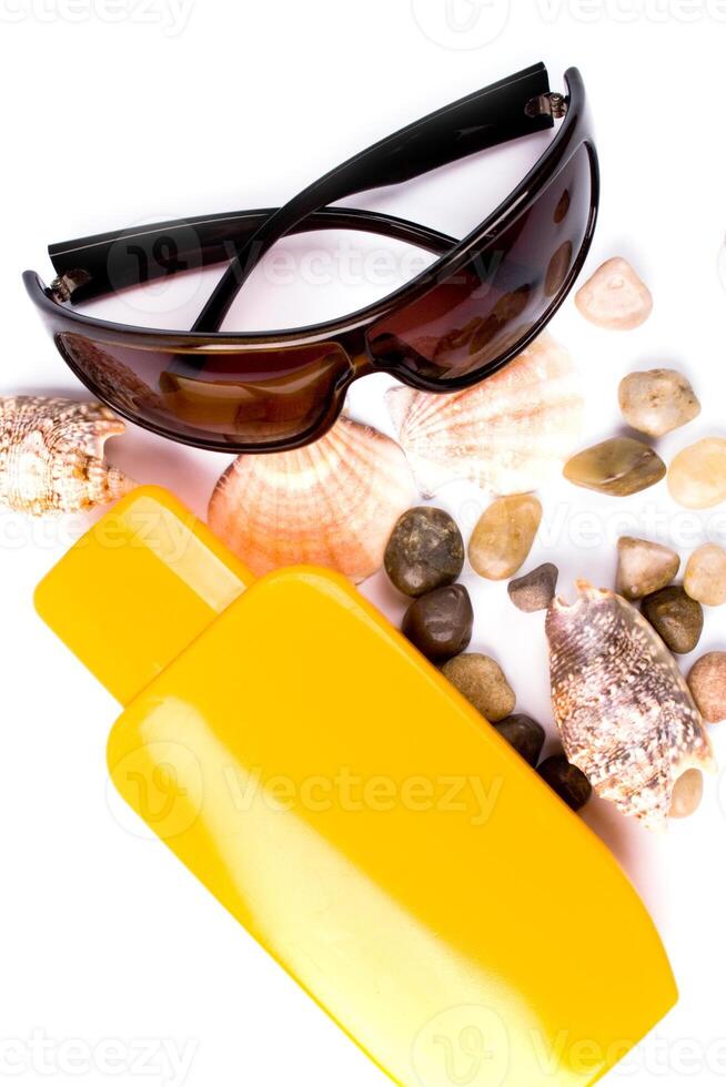 sunglasses, shells and lotion photo