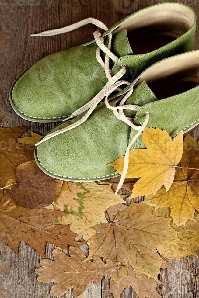 green leather boots and yellow leaves photo