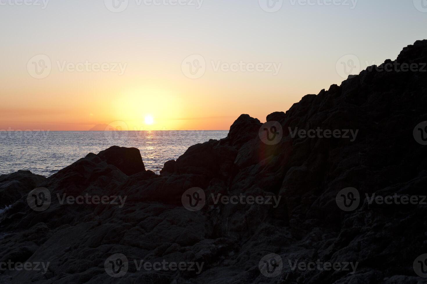 Sunset on the rocky shore. Tyrrhenian Sea. photo