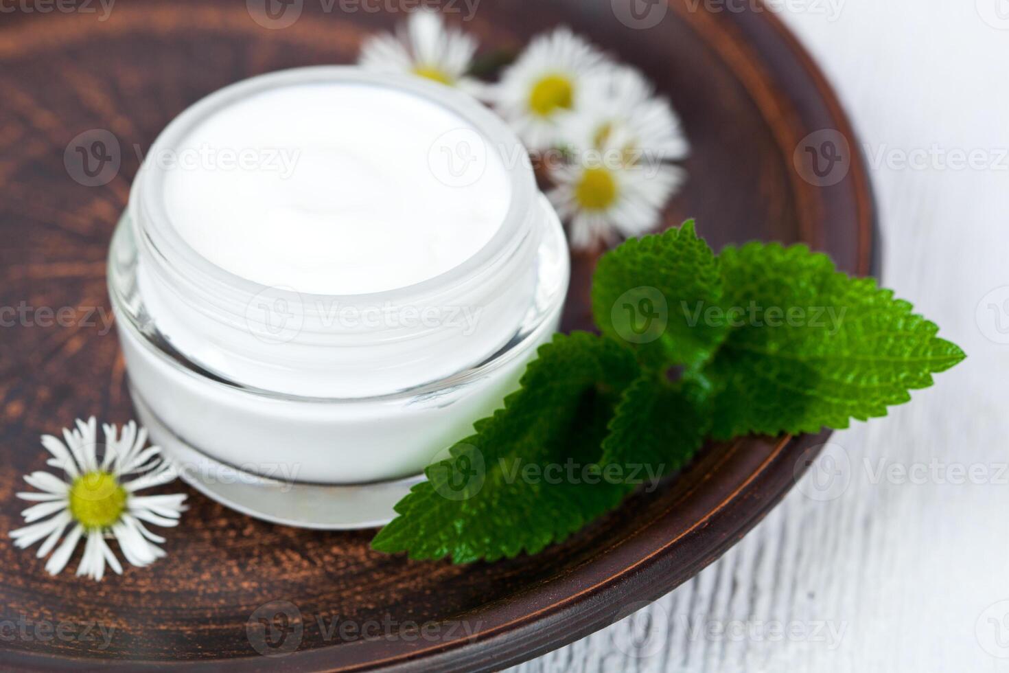 container with cream urtica and chamomiles photo
